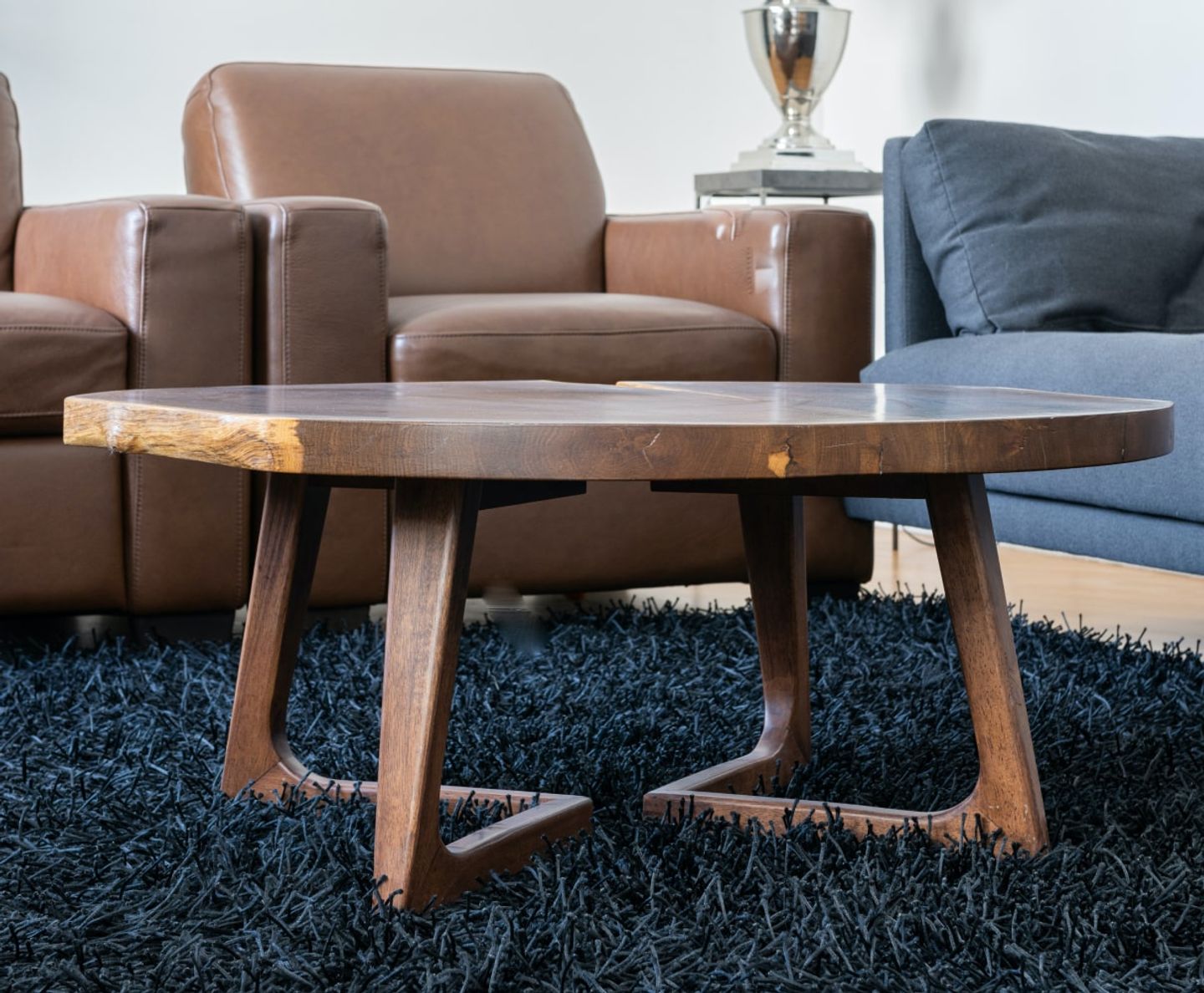Wooden coffee table on a freshly cleaned dark shag rug in a living room