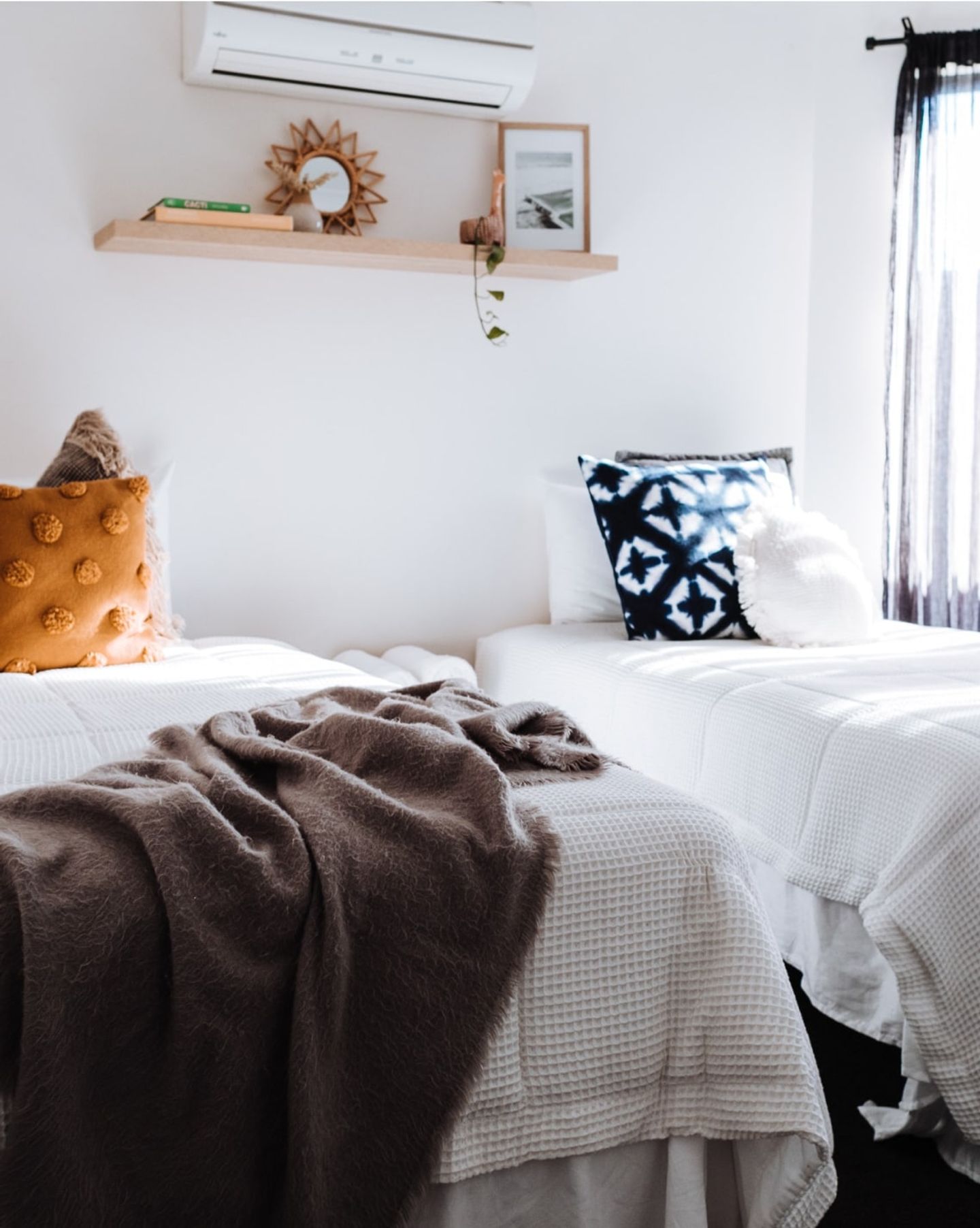 Neatly made twin beds in a bright, freshly cleaned bedroom
