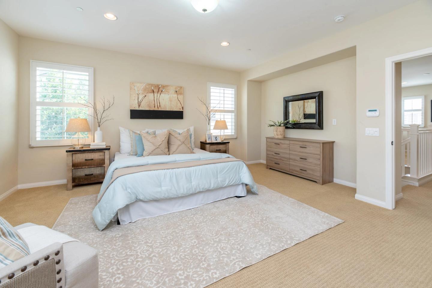Spotless staged bedroom with a made bed, rug and dressers