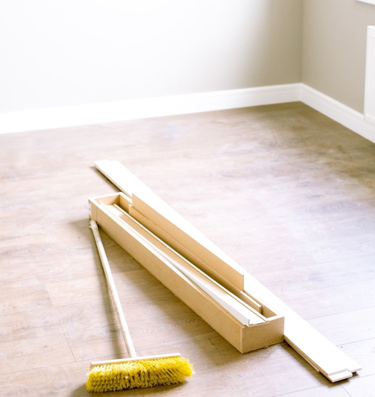 Broom and offcuts on the floor of a freshly renovated room