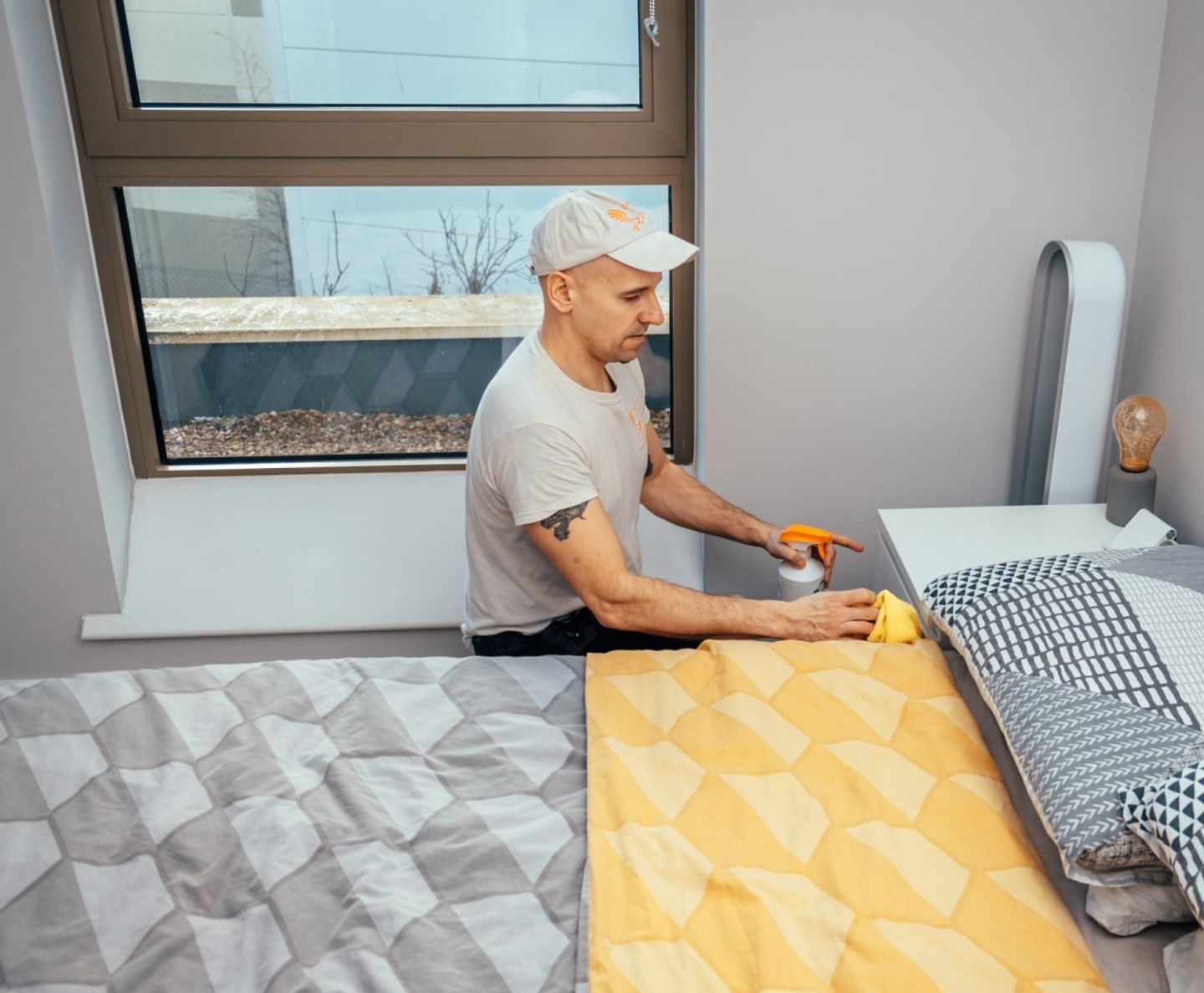 Eagle Family cleaner spraying and wiping a bedside table
