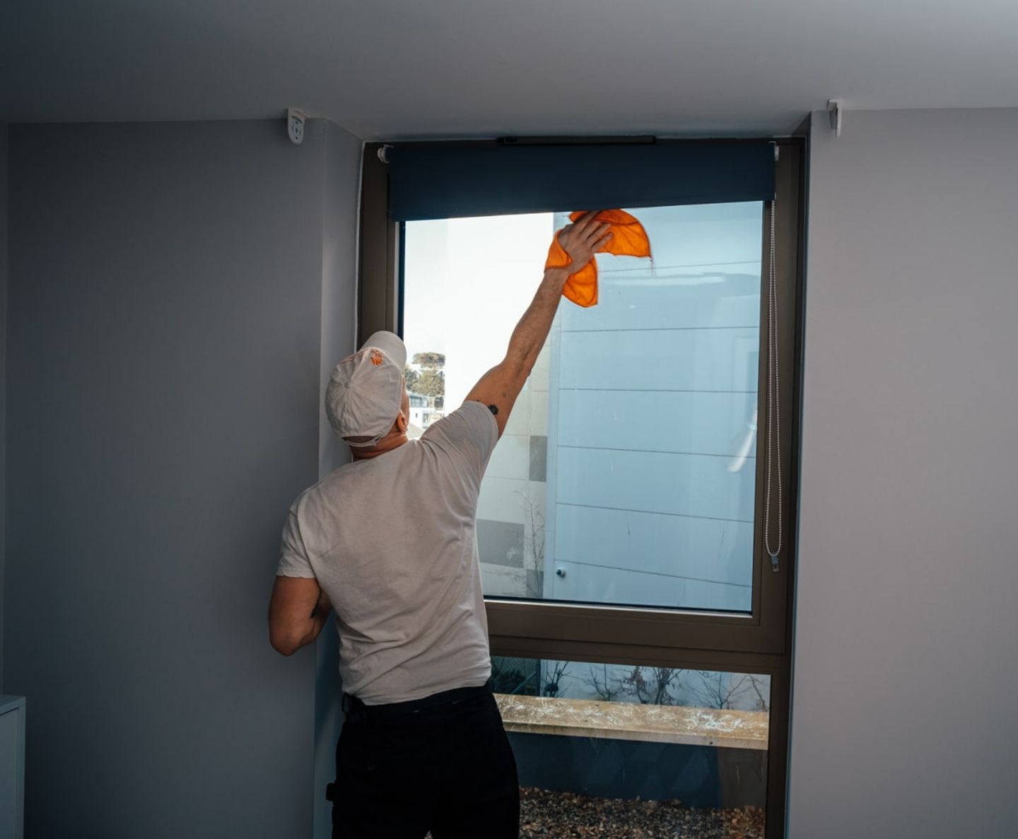 Cleaner wiping a large window with a microfibre cloth