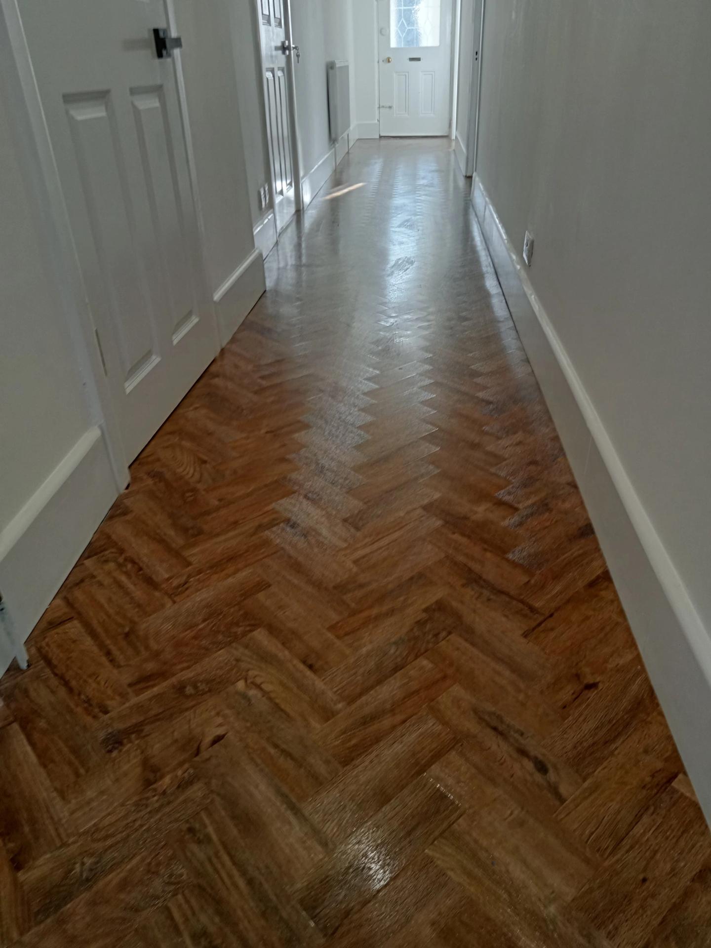 Clean parquet-floored hallway leading to the front door