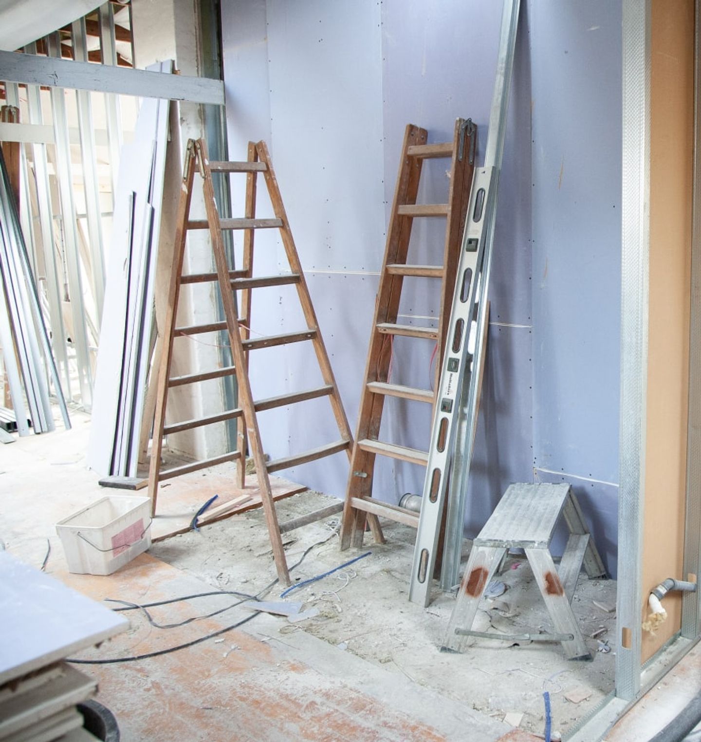 Ladders and building materials in a room under construction before an after-builders clean