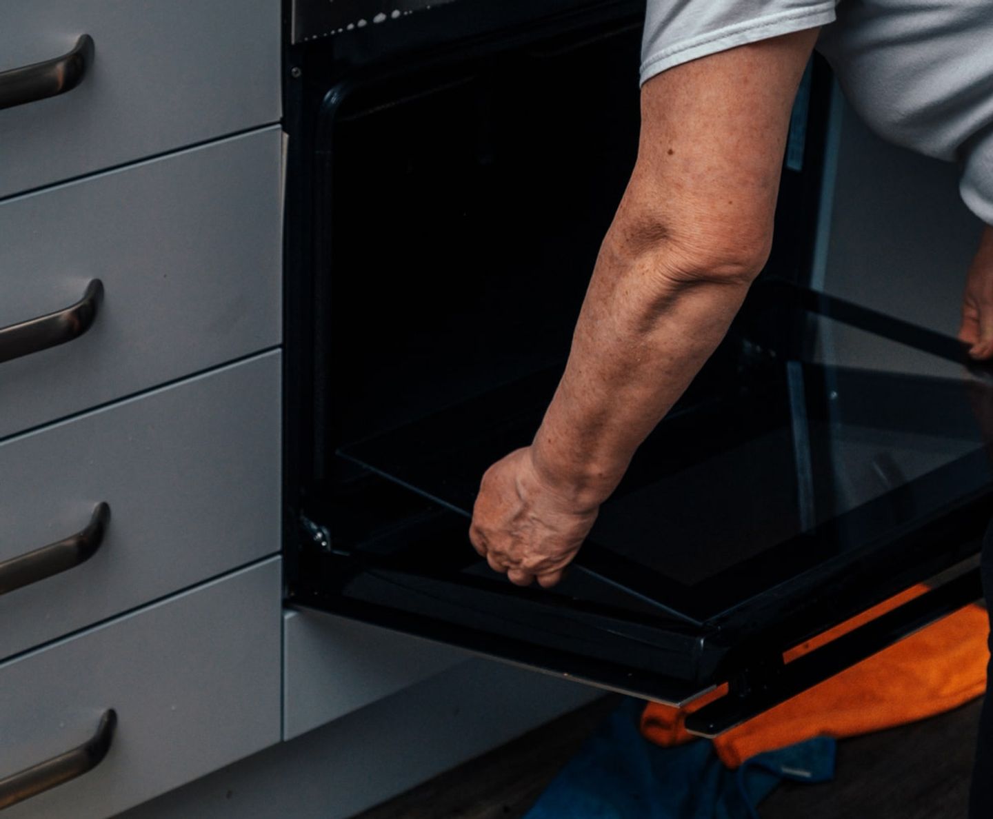 Cleaner removing the glass door panel from an oven for cleaning