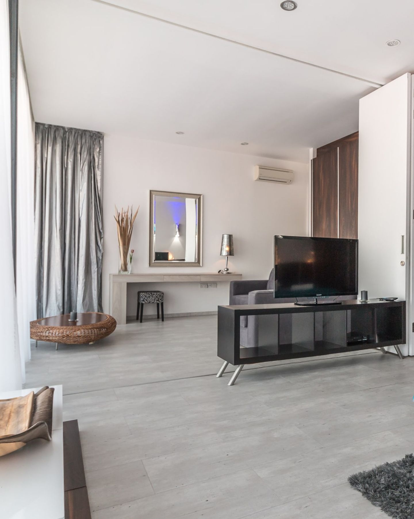 Spacious clean living room with tiled floor and TV unit