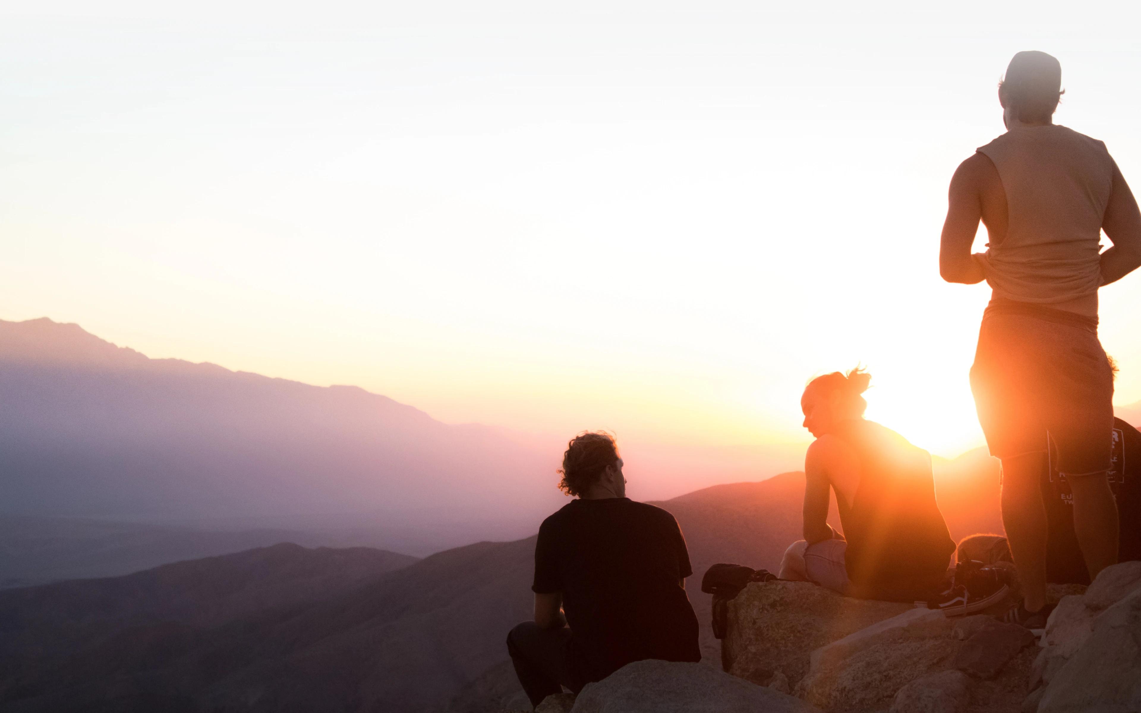 Wedowe imagery: friends watching the sunset from a mountain ridge