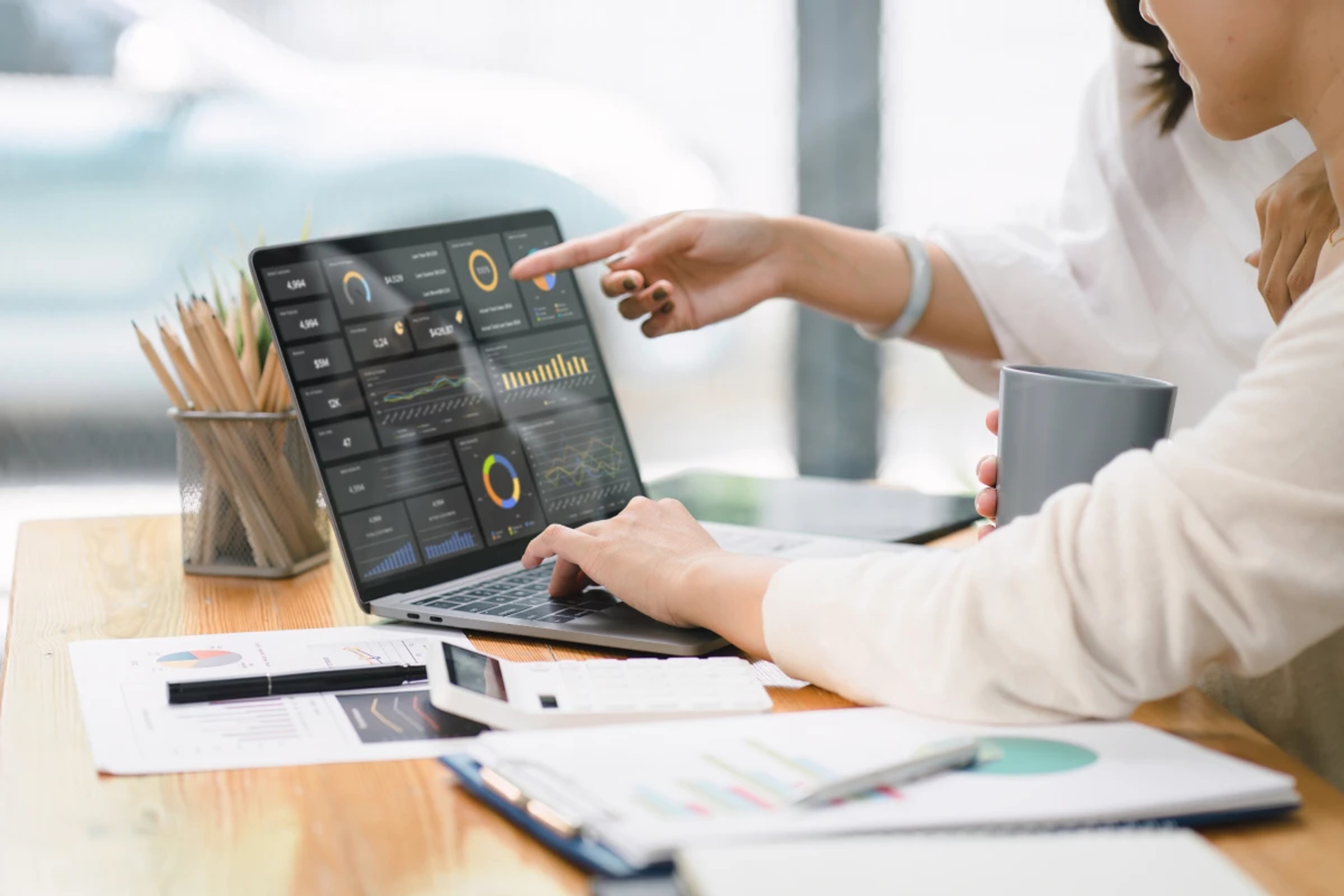 Two people analyzing marketing dashboards with real-time data visualizations on a laptop screen.