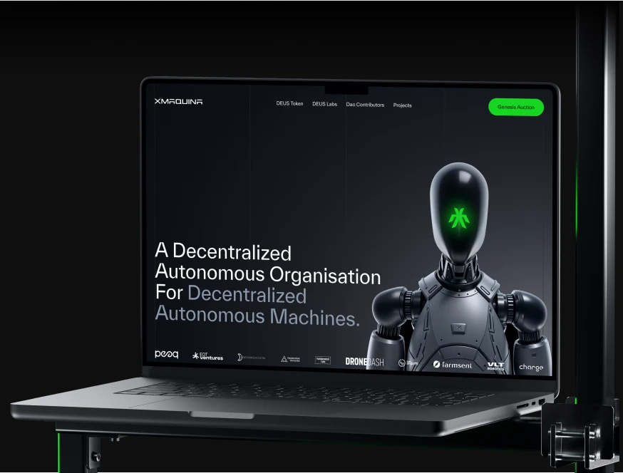 XMAQUINA website on a laptop: decentralized autonomous machines hero with a humanoid robot