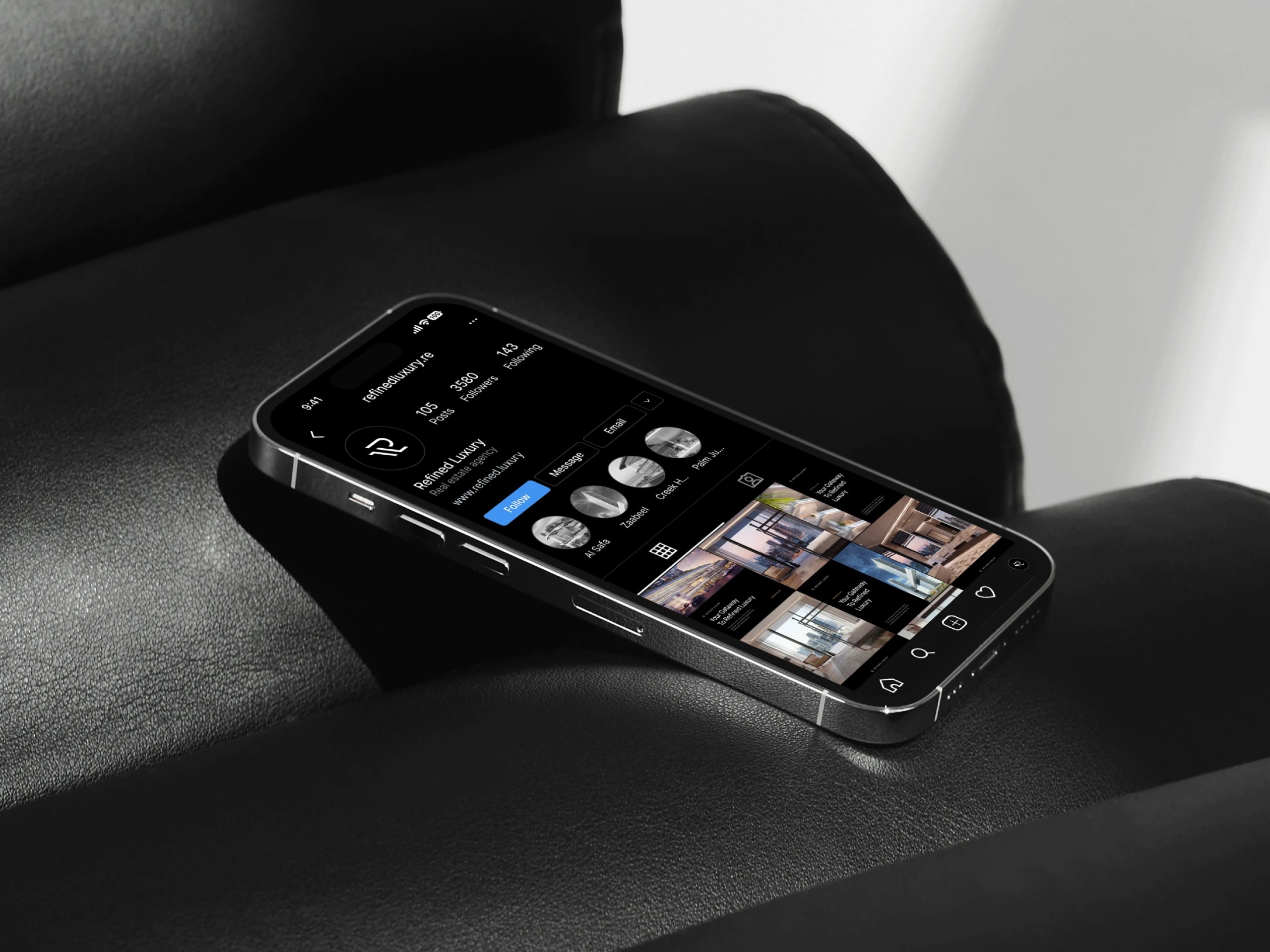 Phone showing the Refined Luxury Instagram profile on a black leather chair