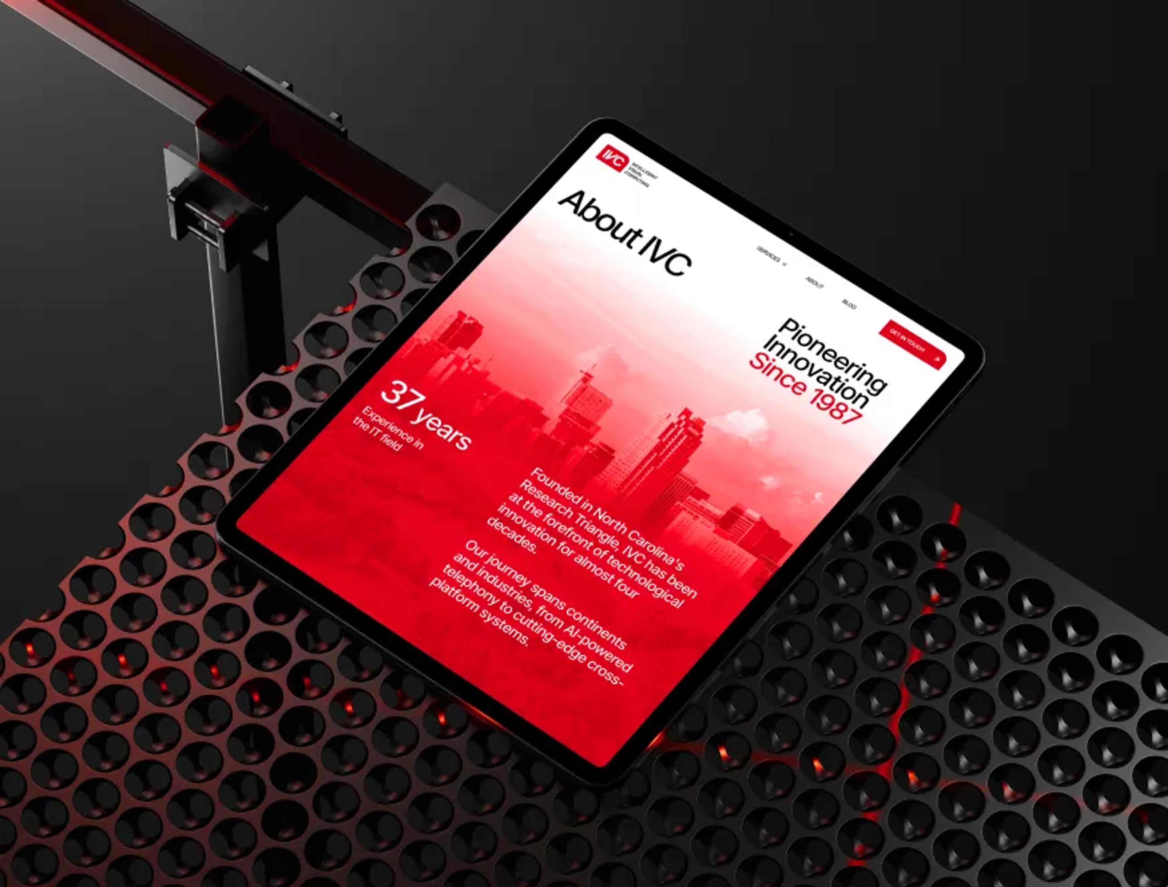 IVC 'About IVC' web page on a tablet: 'Pioneering Innovation Since 1987' with red city skyline