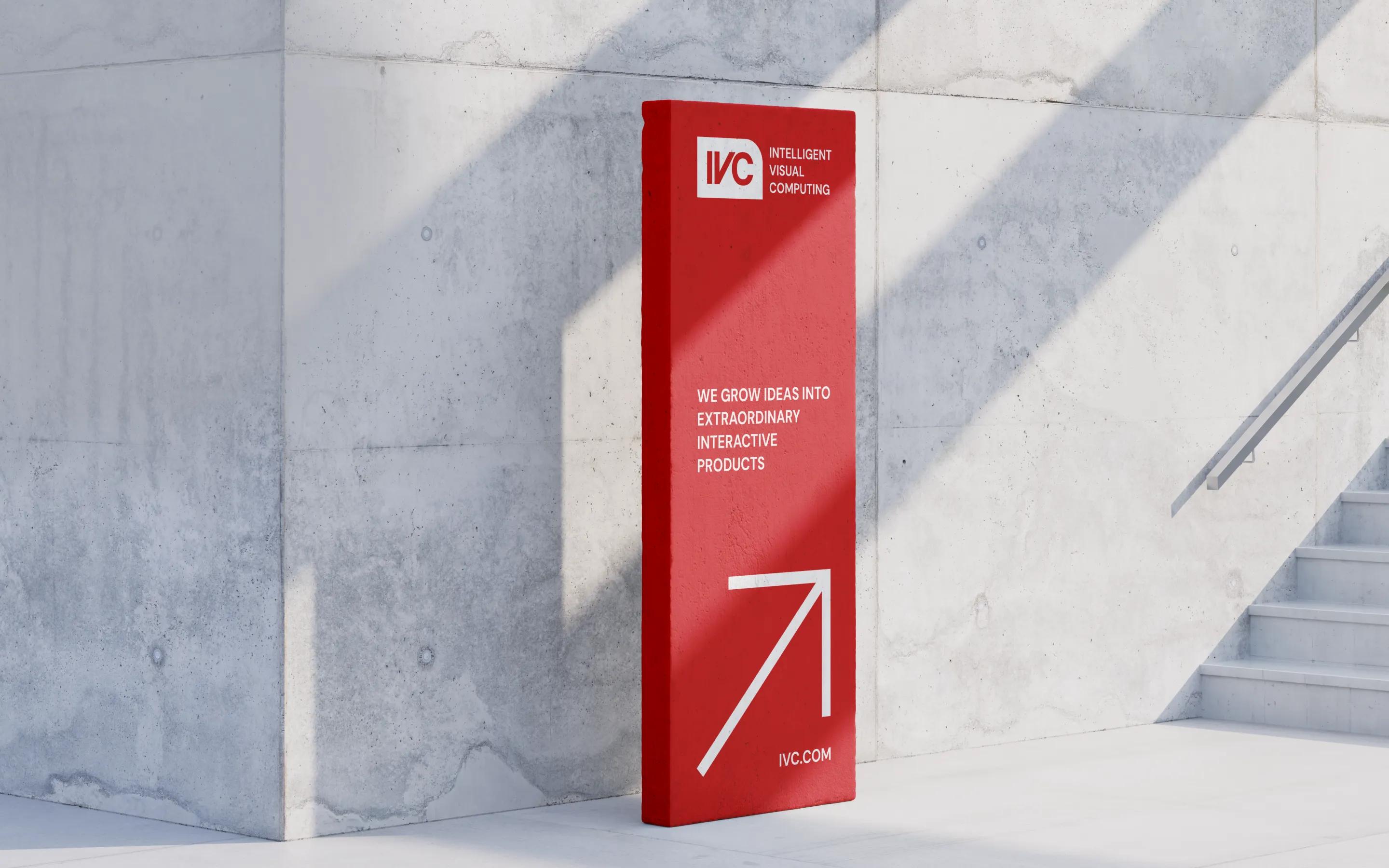 Red signage design for IVC showcasing a bold visual identity with tagline and arrow