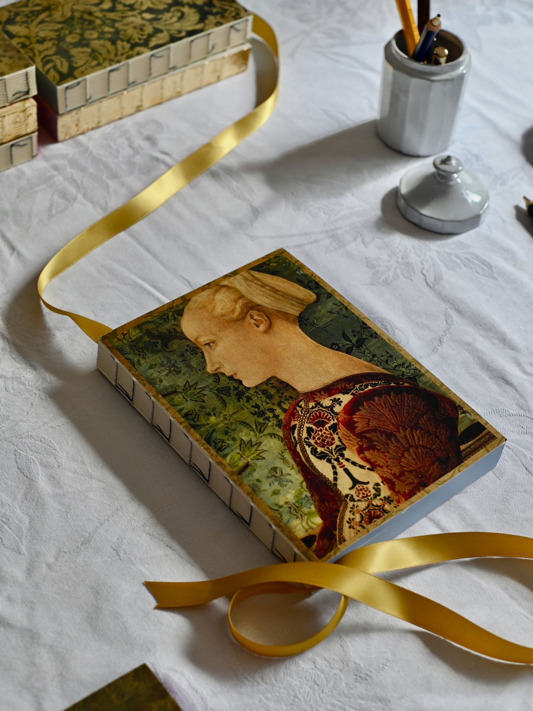 Cover of Lady Notebook with gold ribbon on table
