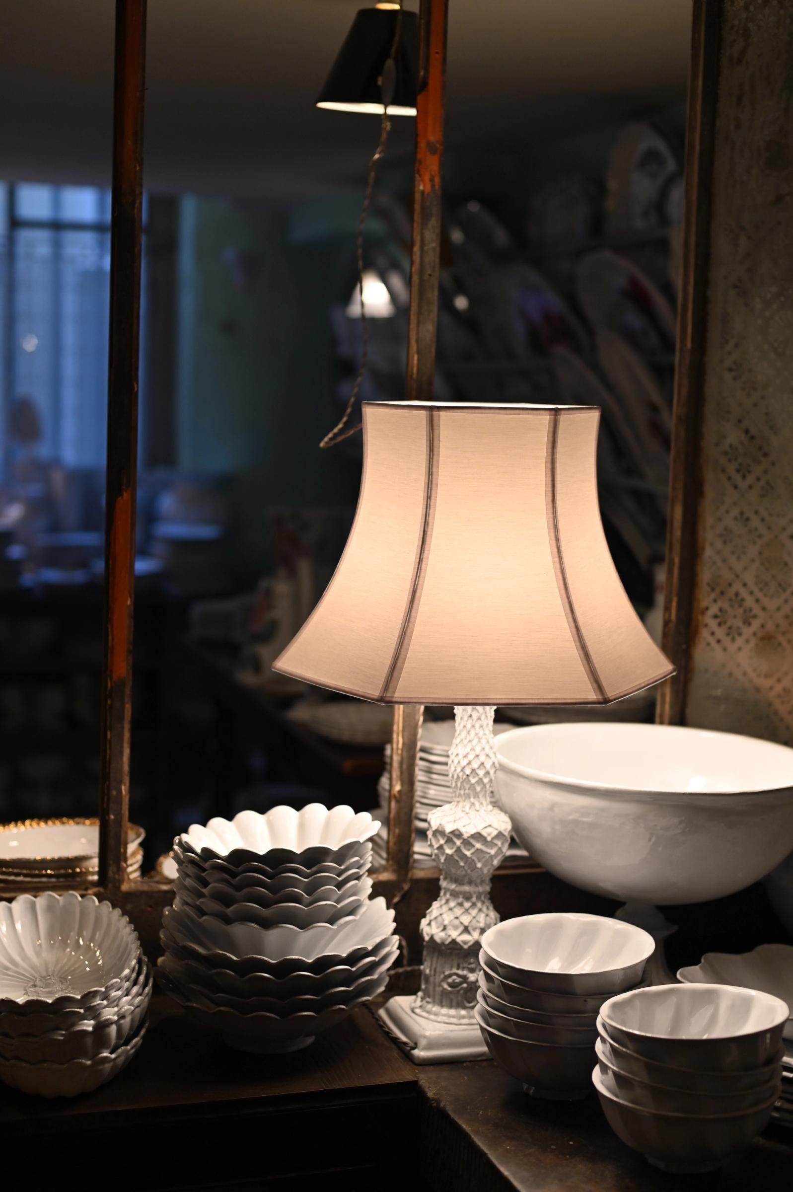 A table lamp with ceramics in the store of Astier de Villatte, Paris