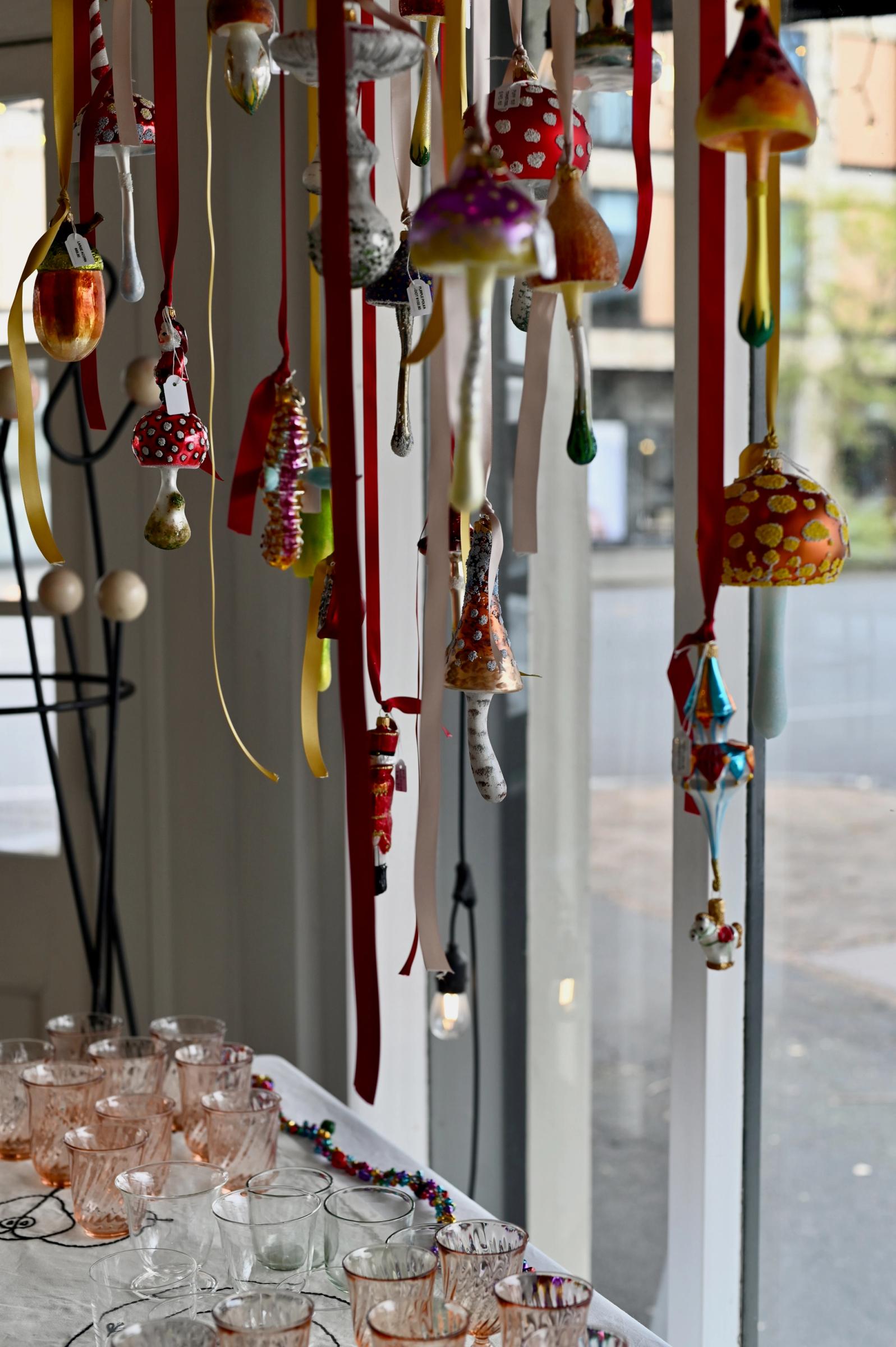 decorations hang in window from coloured ribbon