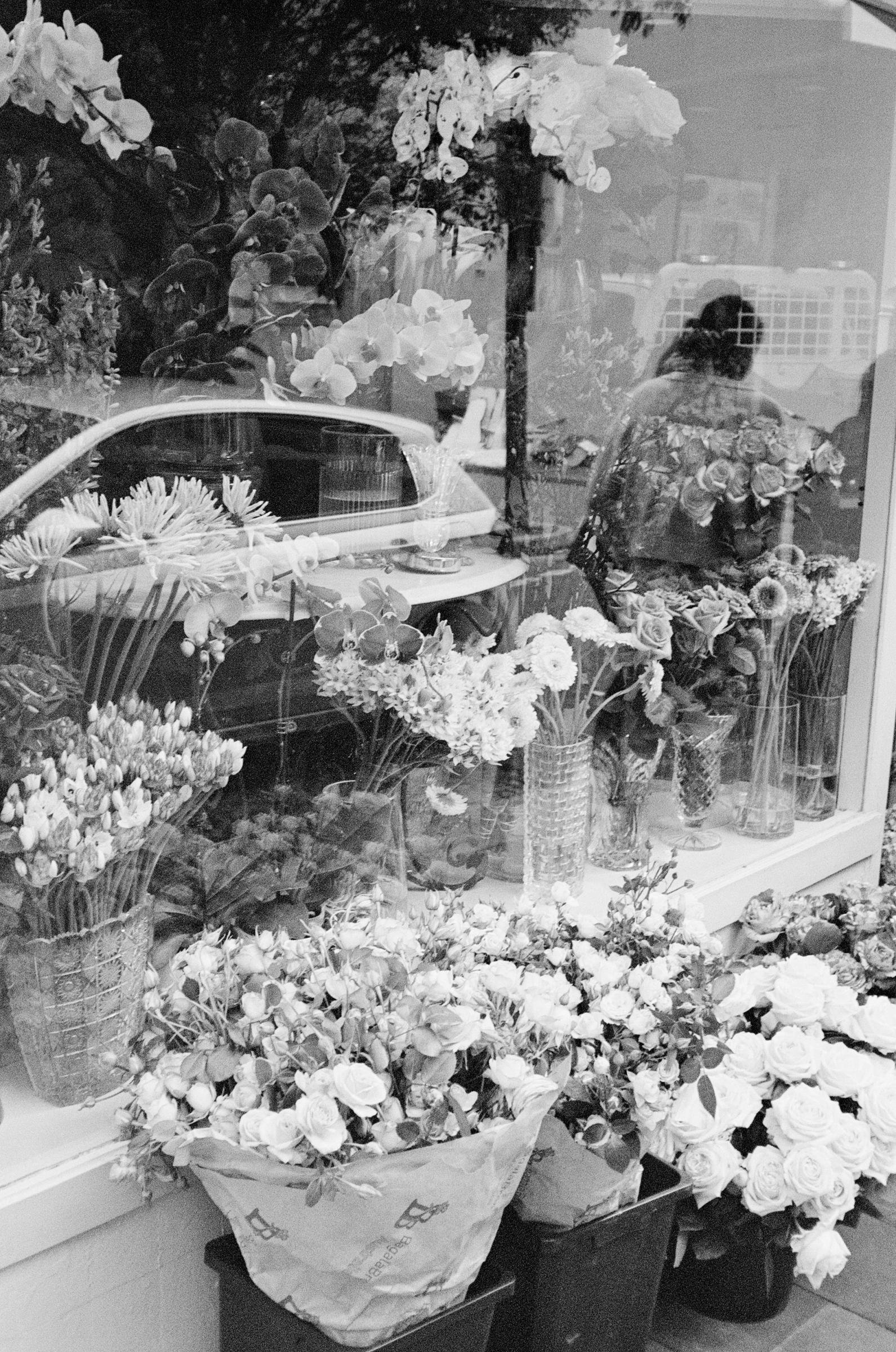black and white image taken from outside a florist shop