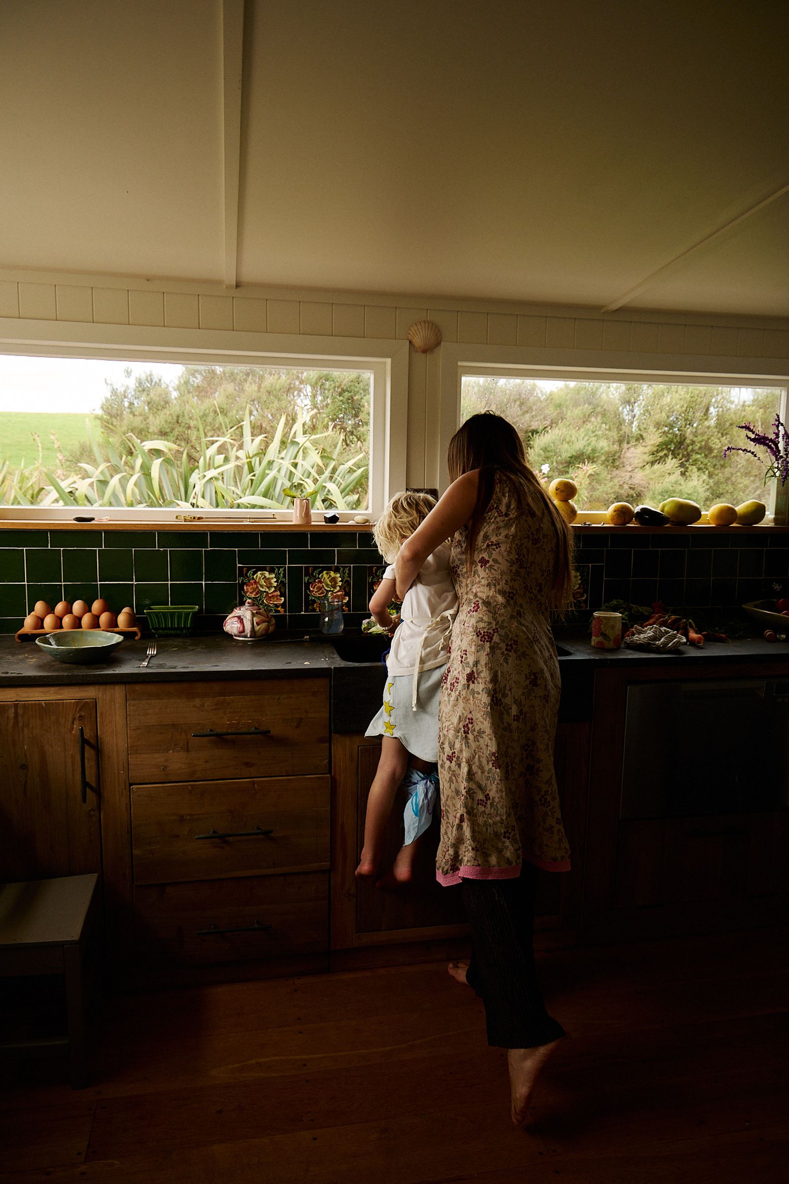 mother hold boy over sink to wash his hands