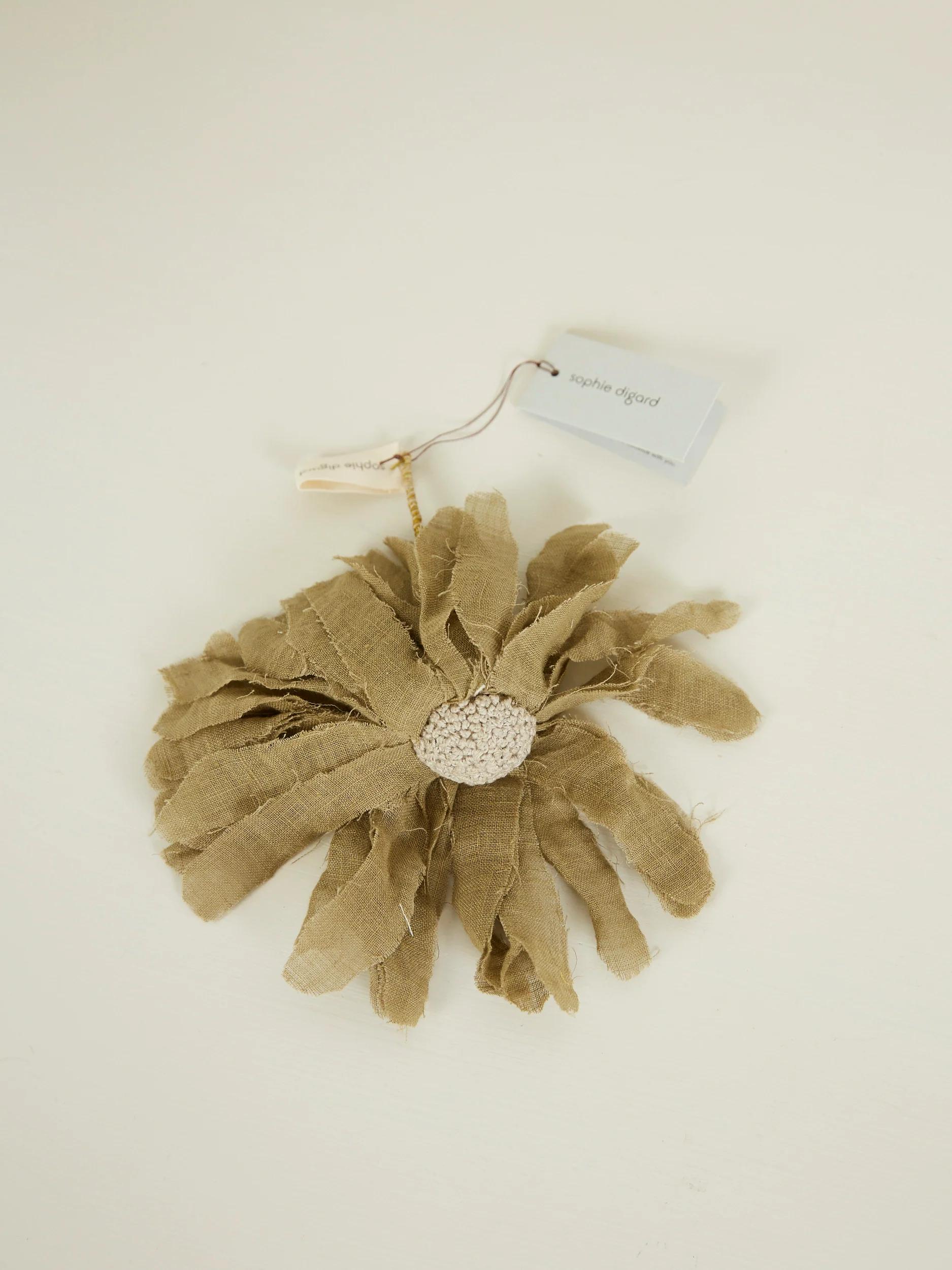 Handmade tan fabric flower with frayed edges. Textured centre. "Sophie Digard" tag attached.