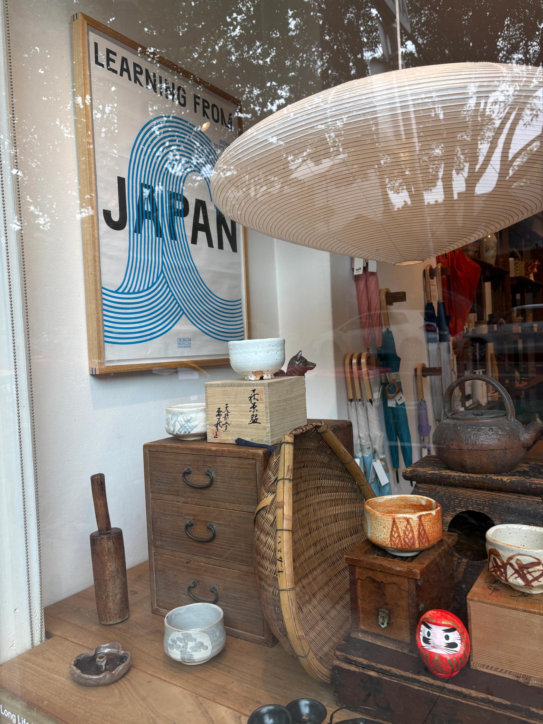 window installation of japanese crafts and vintage lamps and posters