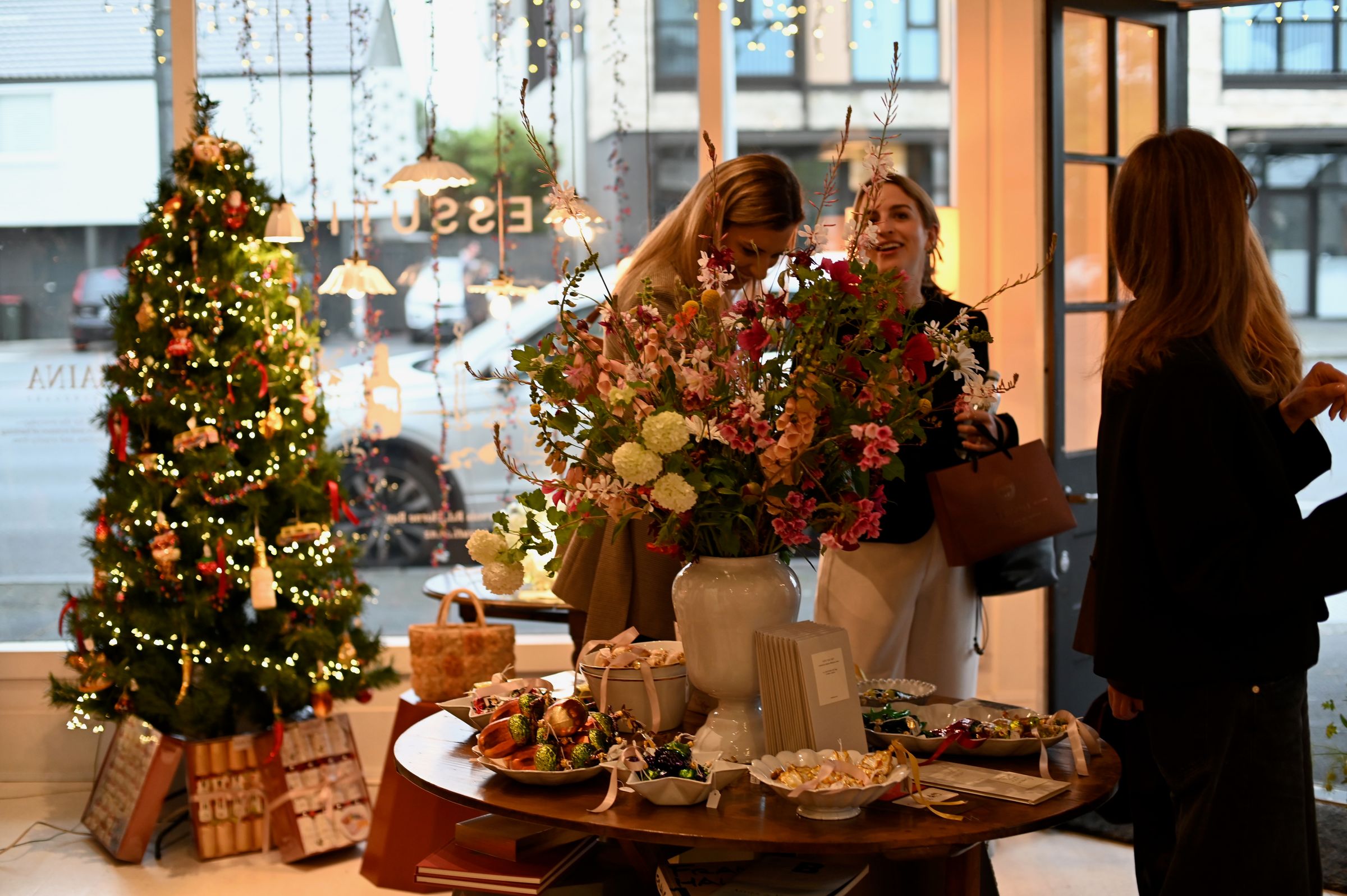 guests at our christmas store event in front of the flowers