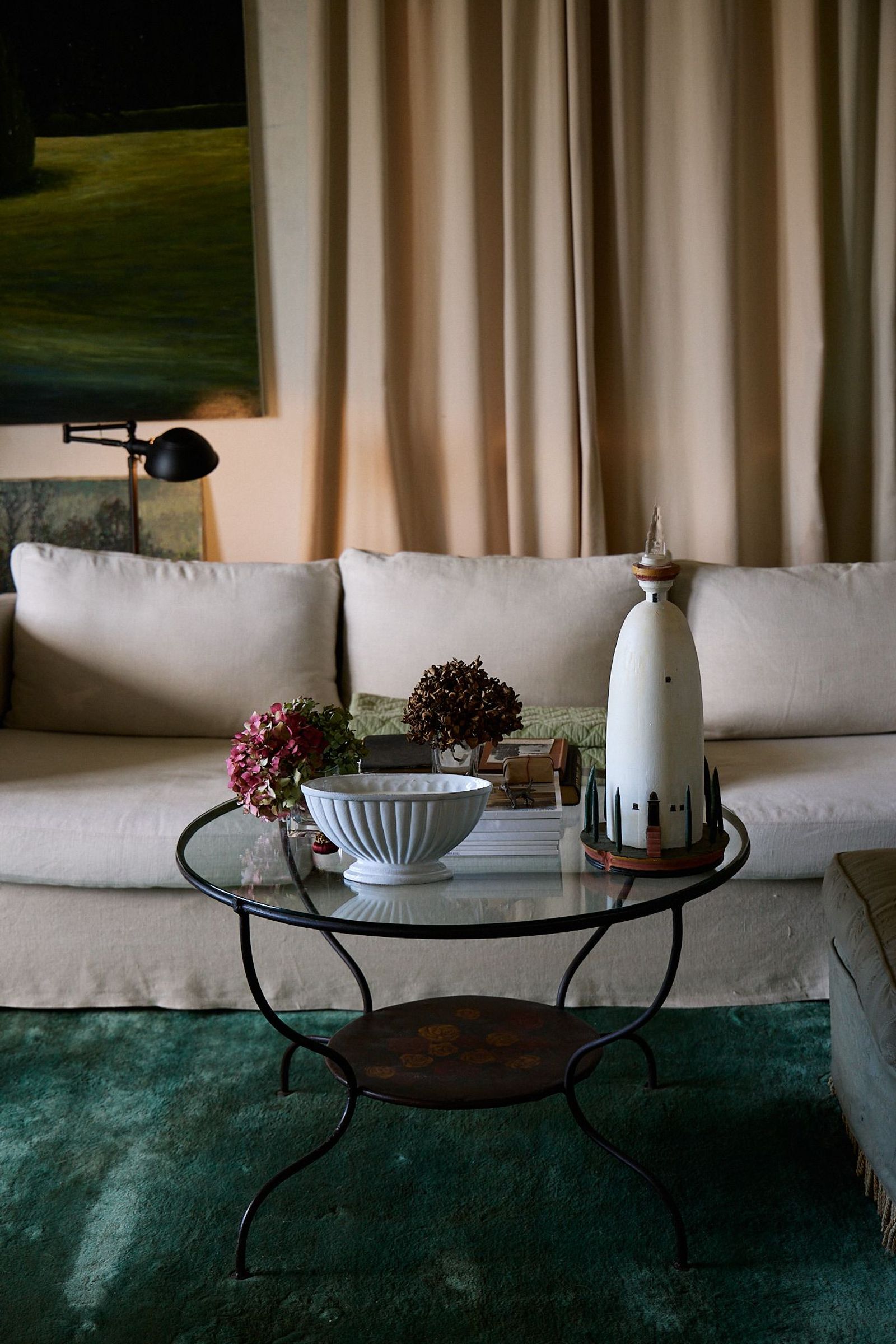 a lounge room with metal coffee table and green rug 