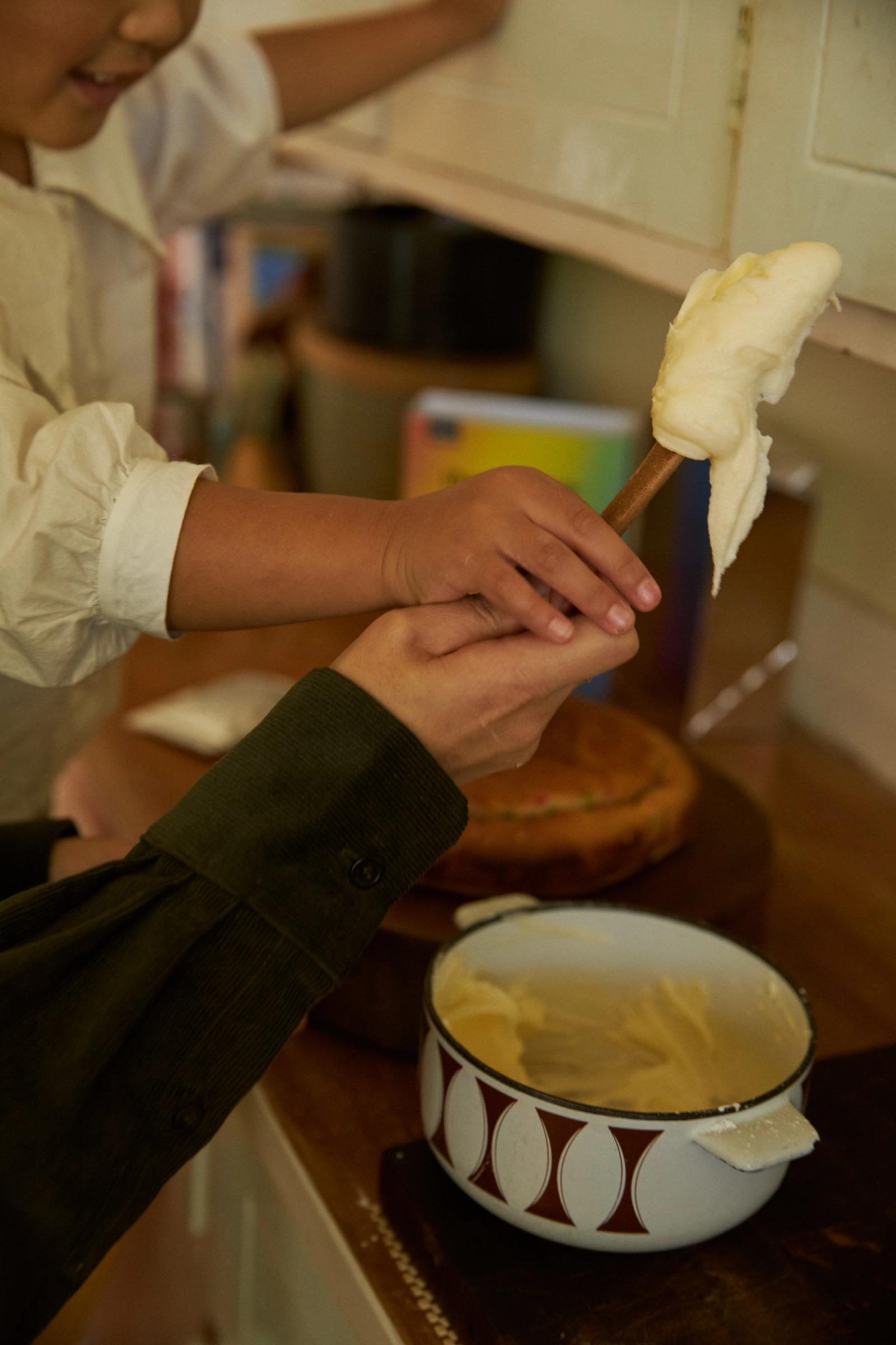 two hands hold a stick of icing for a cake