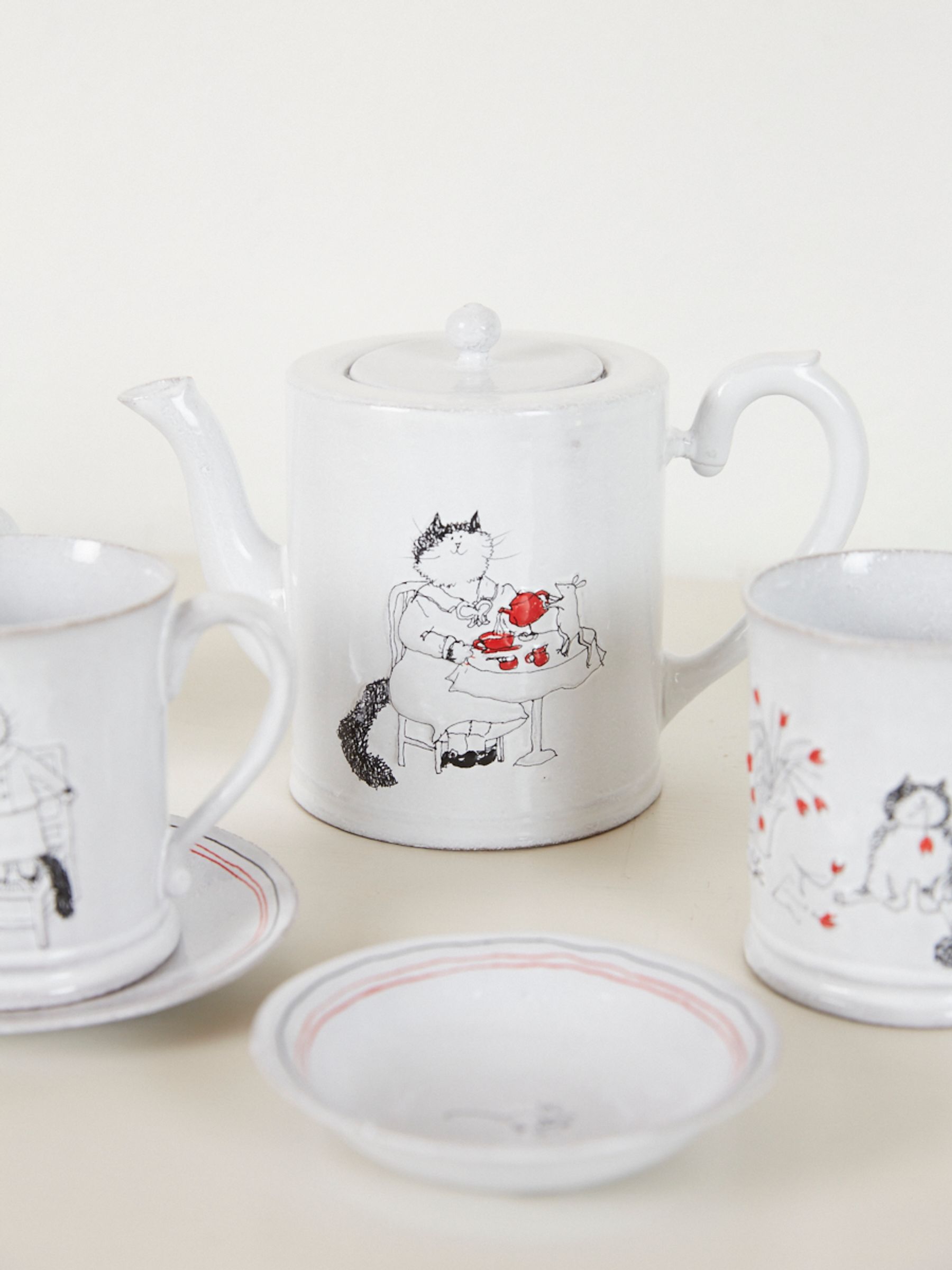 Ceramic teapot with an illustration of a mother cat sitting at a table for tea