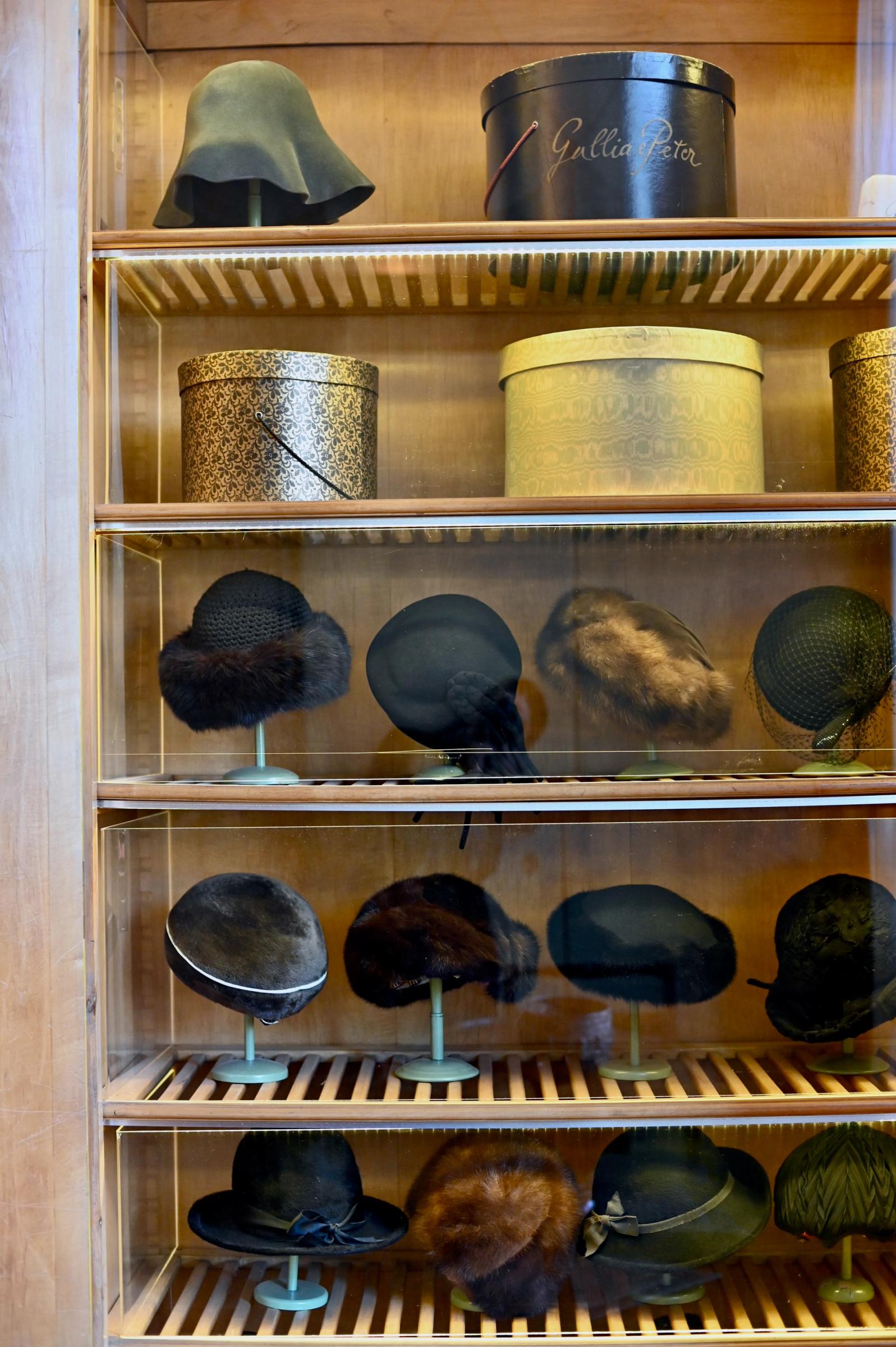 a cupboard filled with textured hats and their boxes