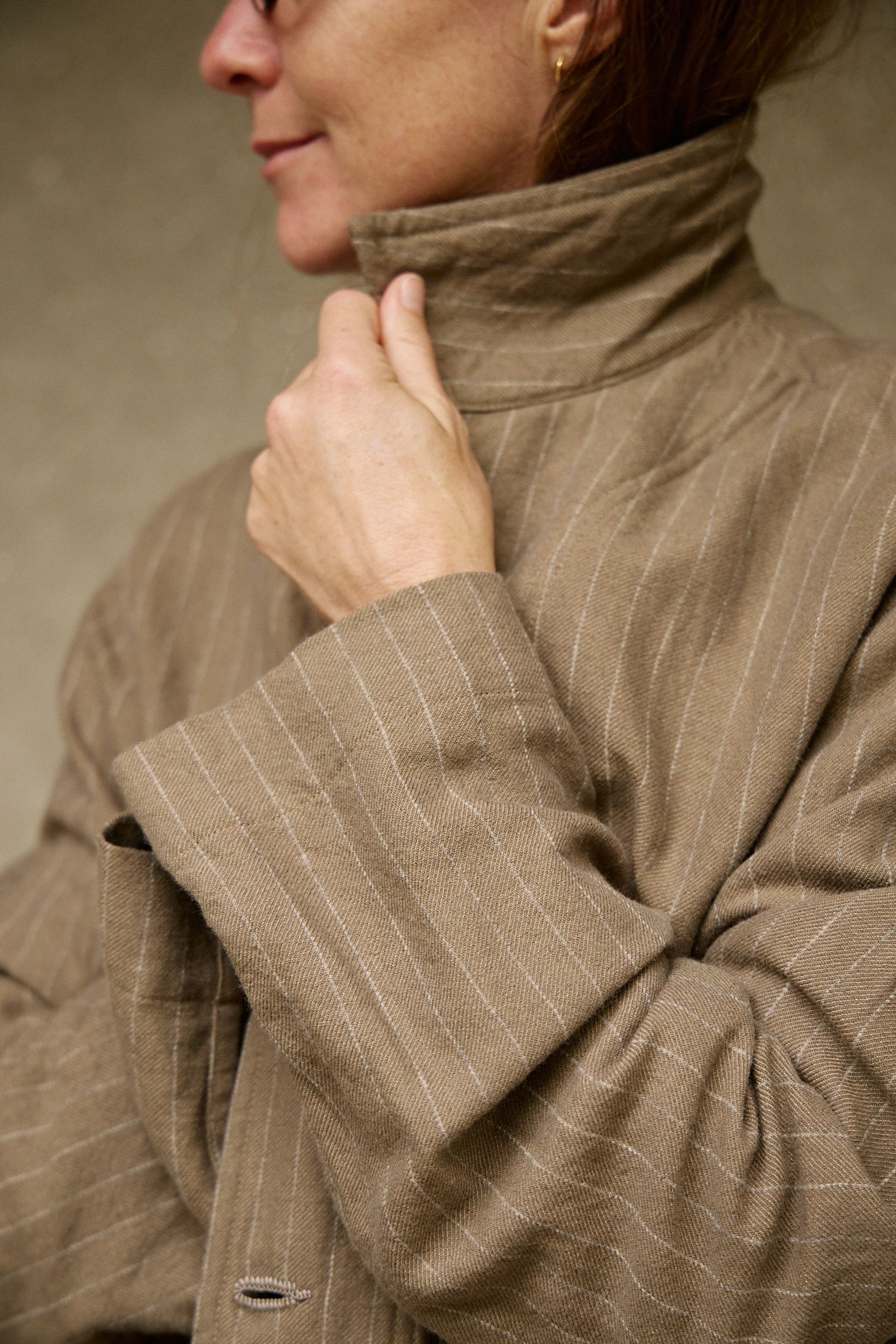 long coat with pinstripe styled with collar up and wrapped