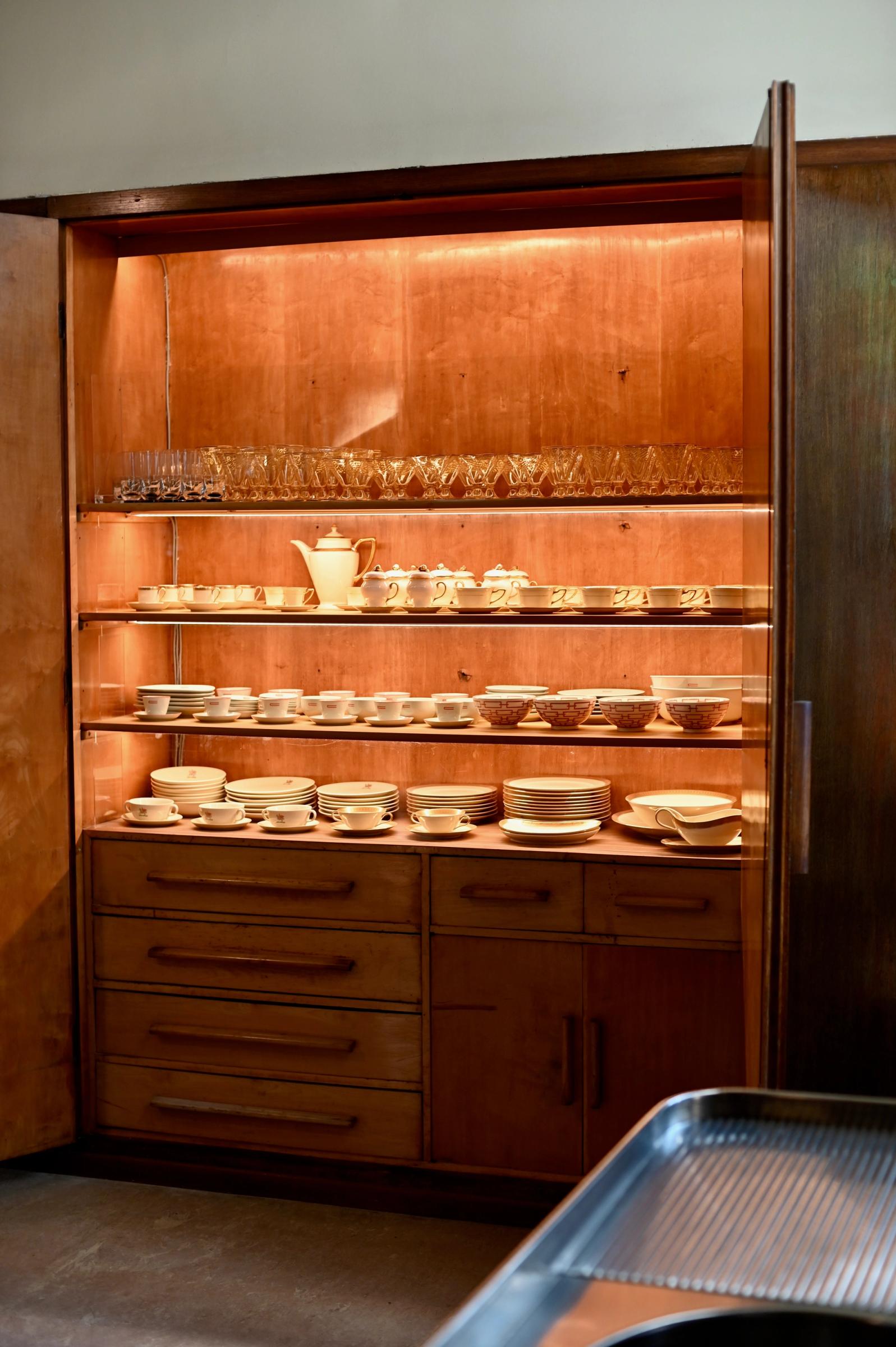 a wooden cupboard full of china tea sets and plates