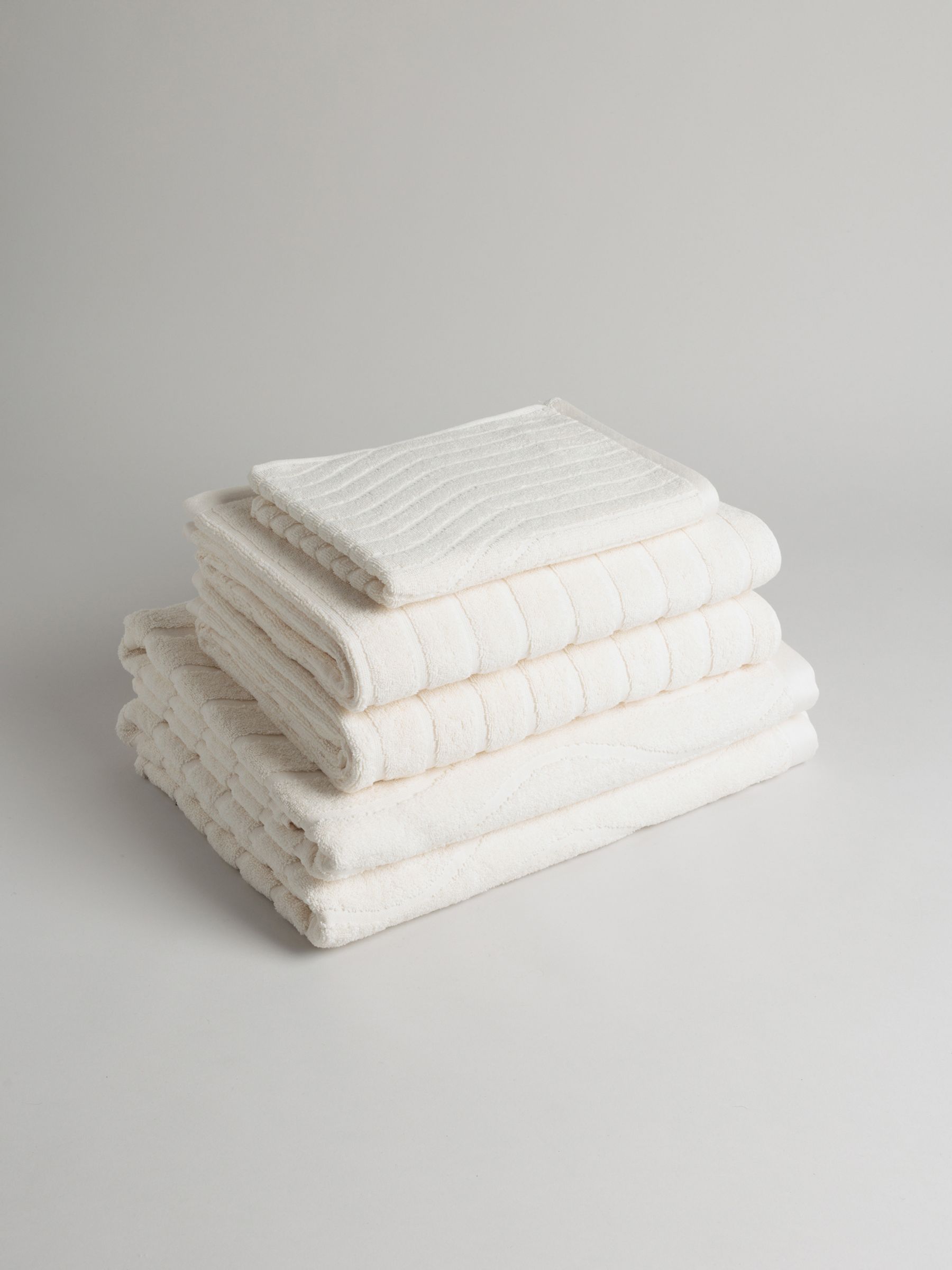 Stack of folded towels in Ivory on a Neutral background.