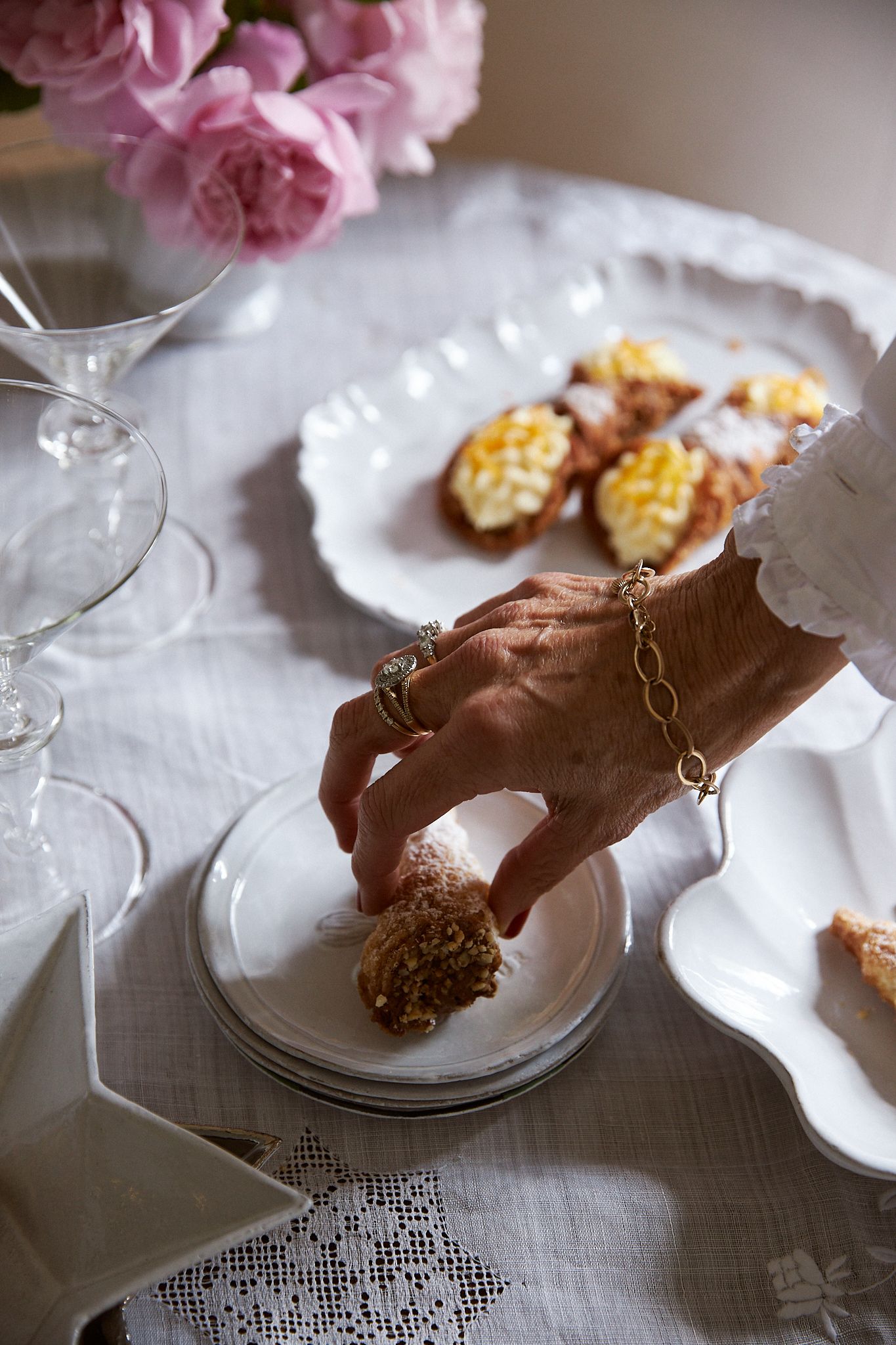 Ali's hand places Italian pastries onto white ceramic plates