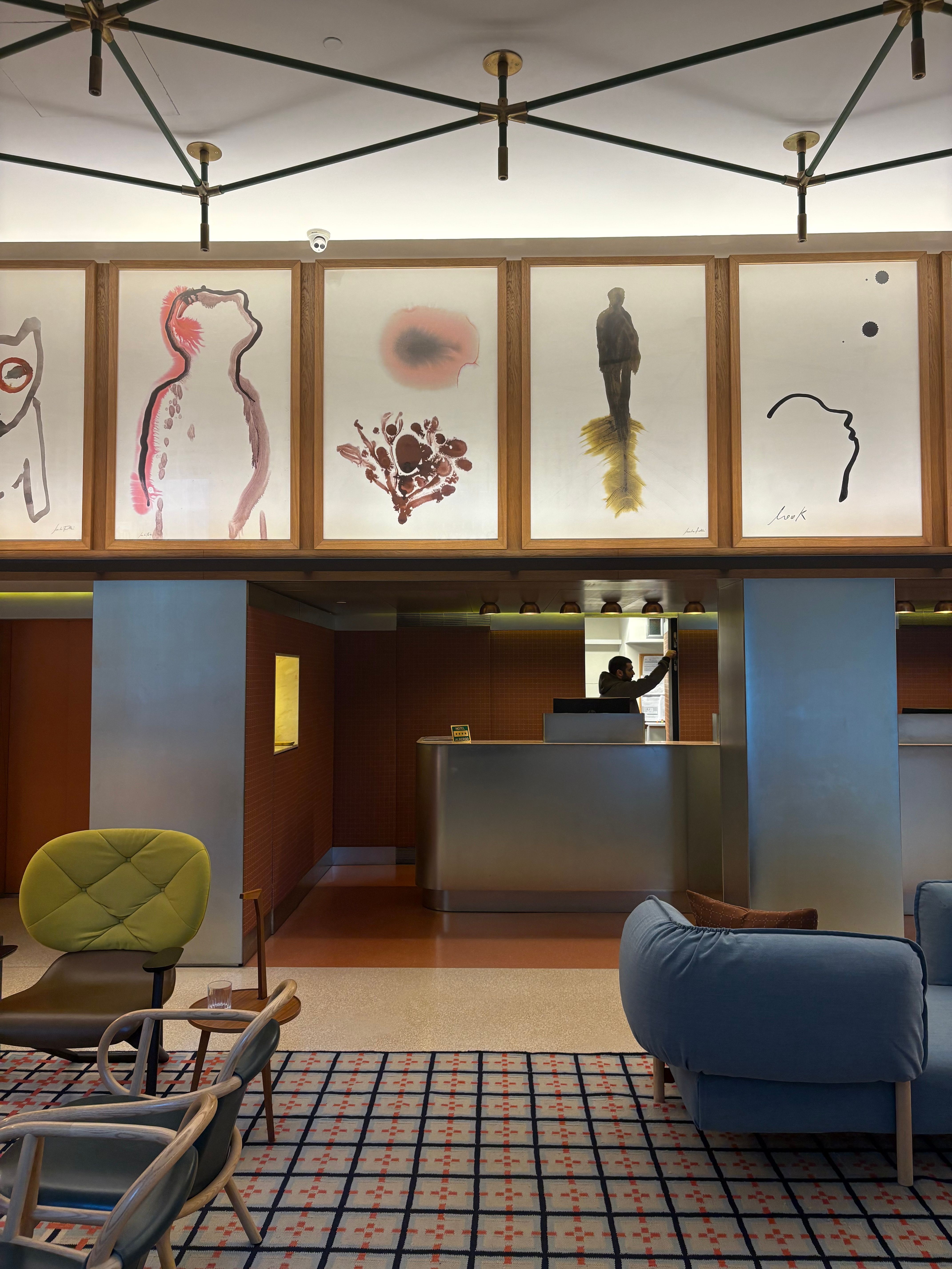 a hotel lobby features watercolour paintings and colourful furniture