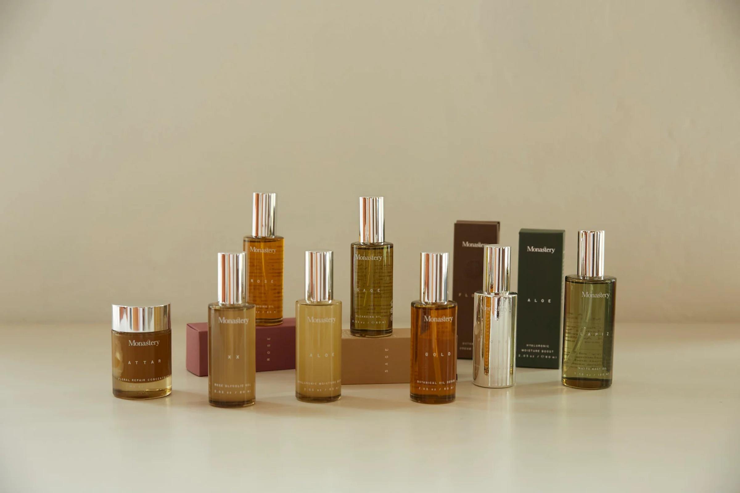 Nine Monastery skincare products in various bottles and boxes, neatly arranged on light-coloured surface.