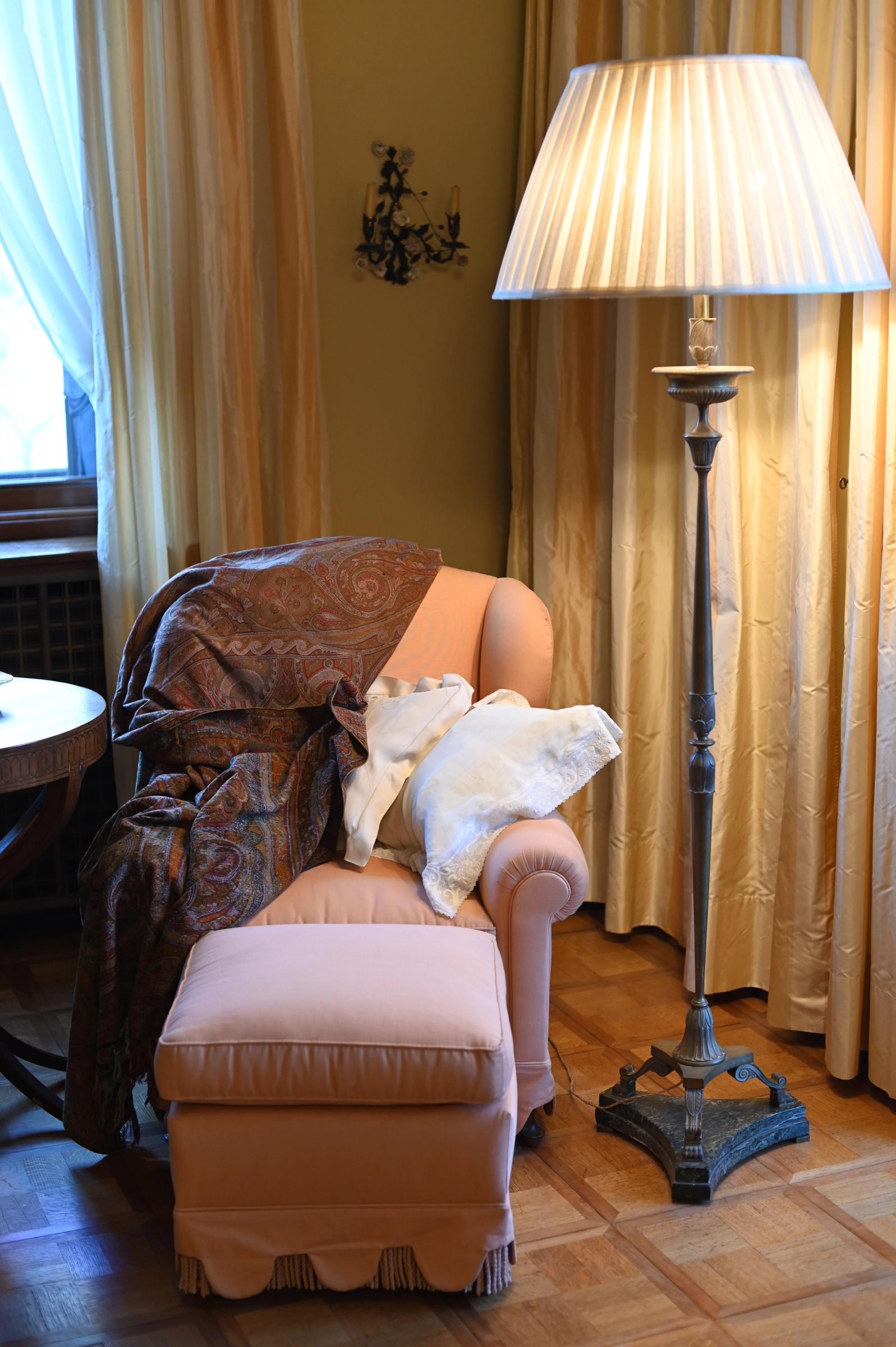a brown paisley scarf is draped over a pink chair
