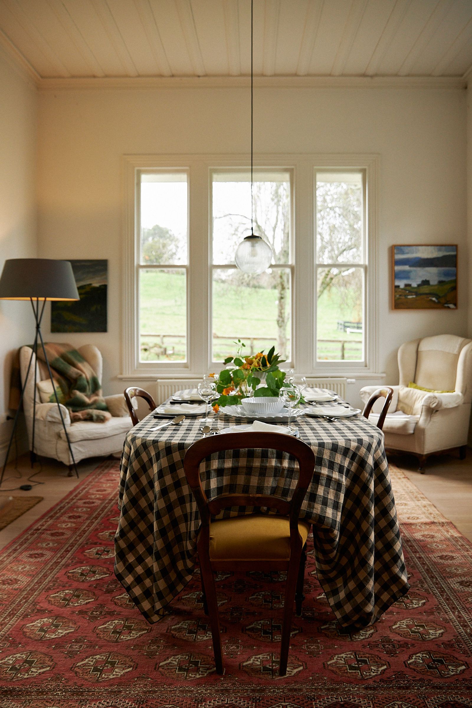 wide shot of the dining room with Persian rug and gingham dining table