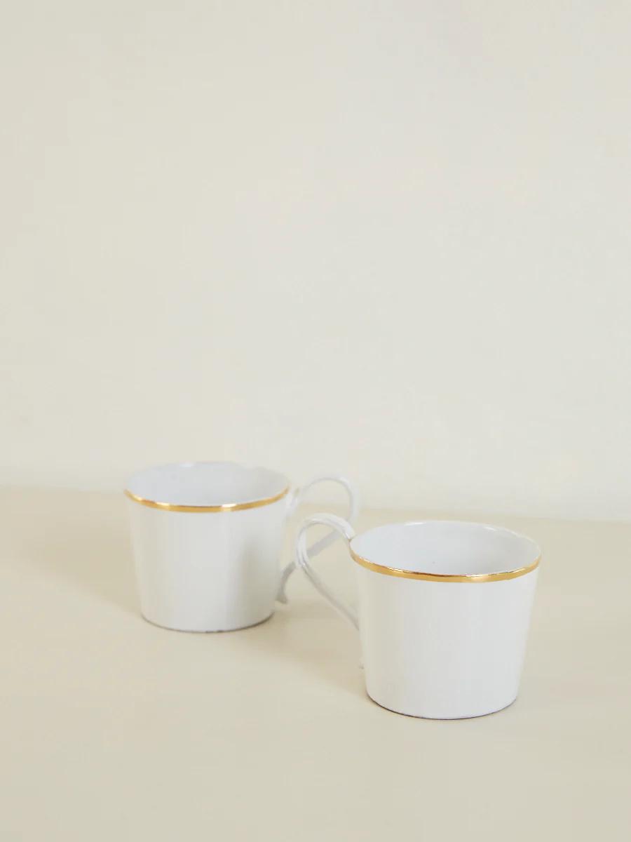 Two white gold-rimmed mugs on cream surface. Purple shiso leaves nearby.