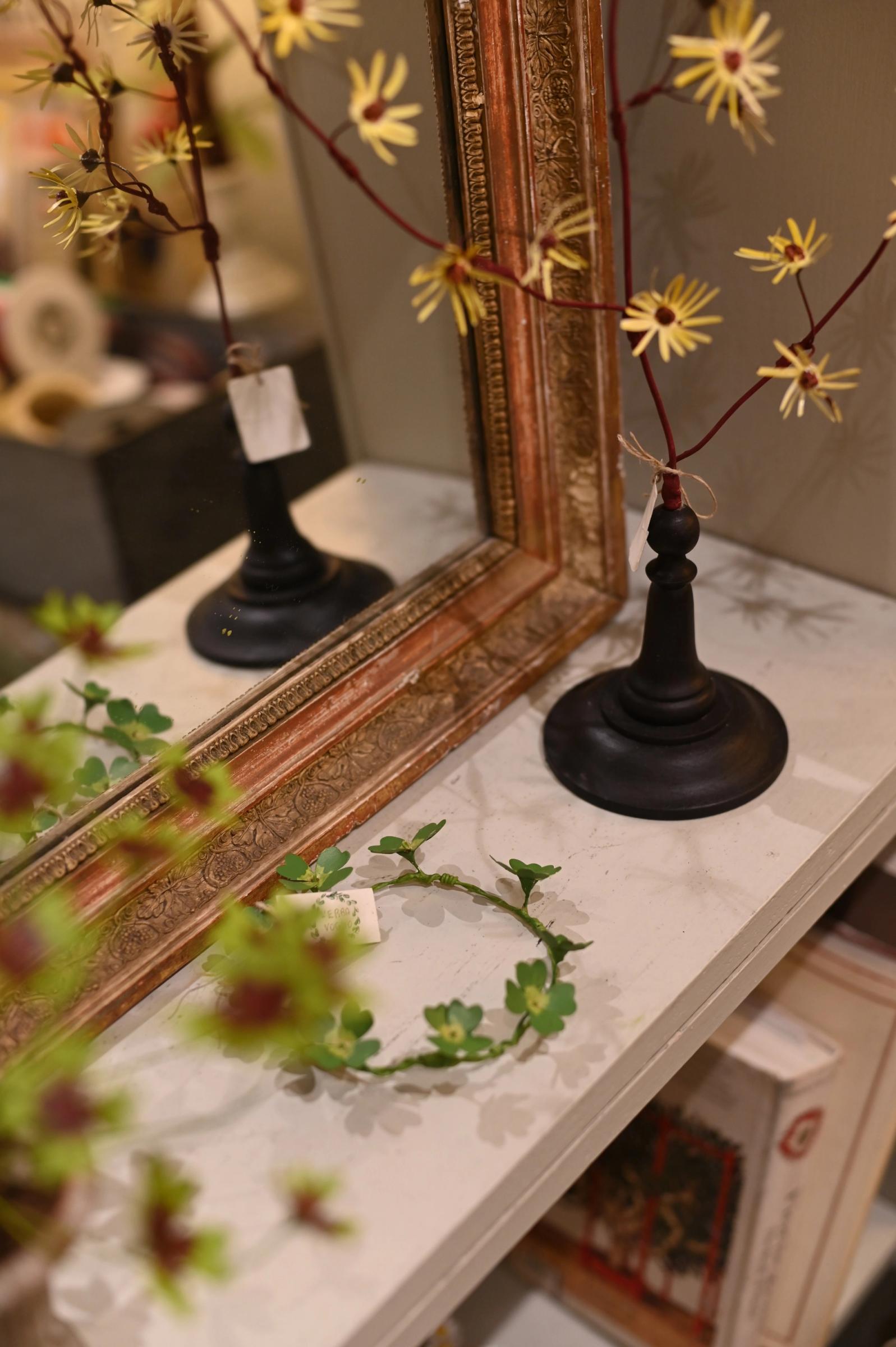 close up of flower sculpture and garland detail against a mirror