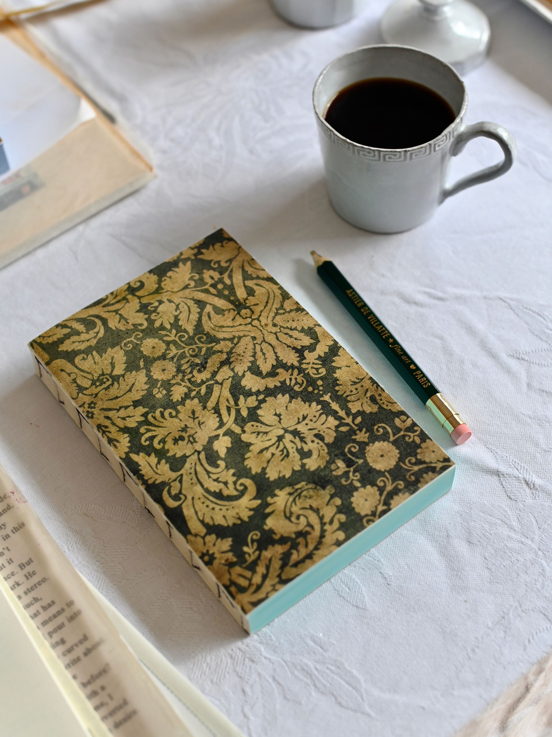 Small Notebook Teal Damask on table a pencil with coffee