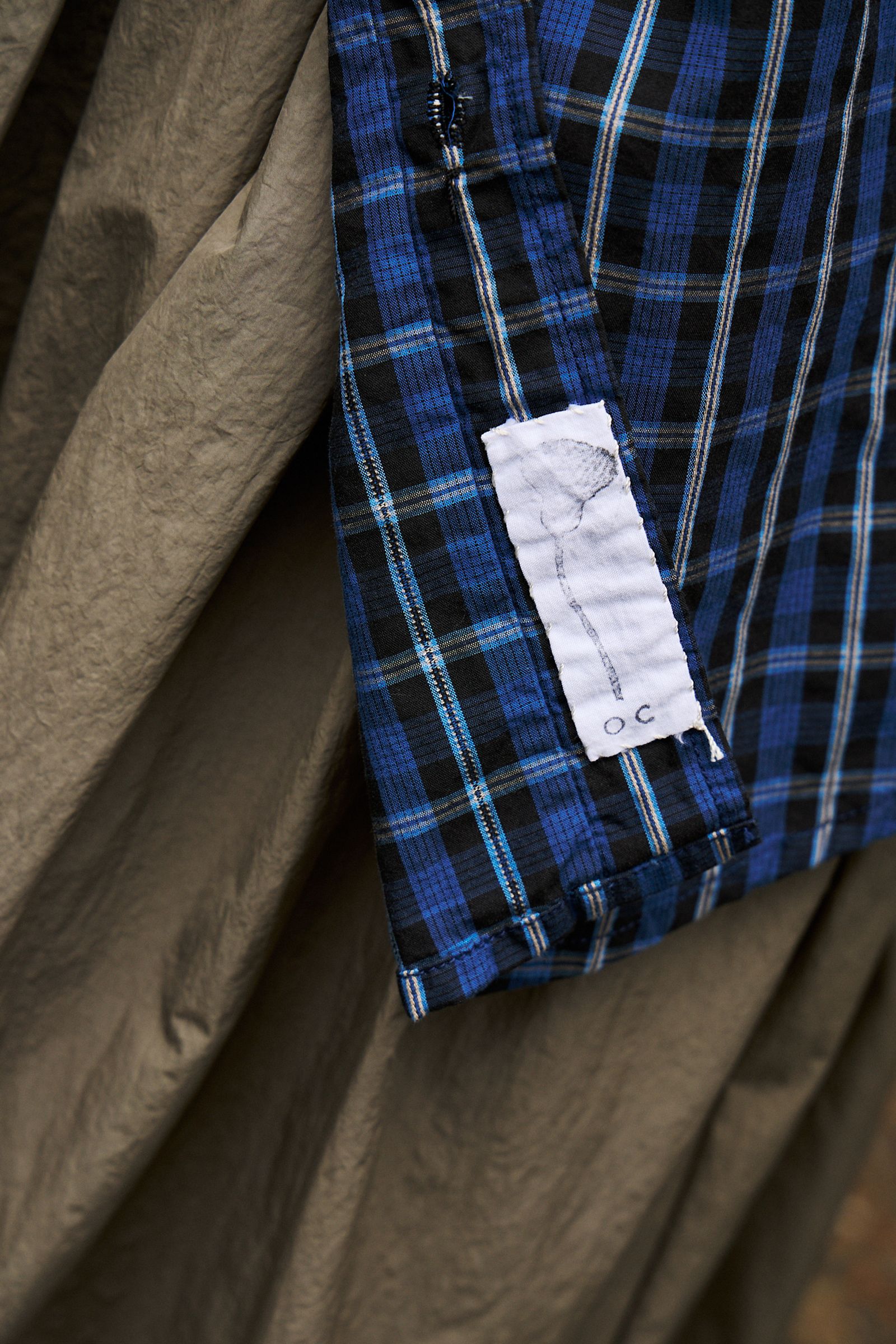 close up of Oliver Church Singular Garments hand sewn logo 