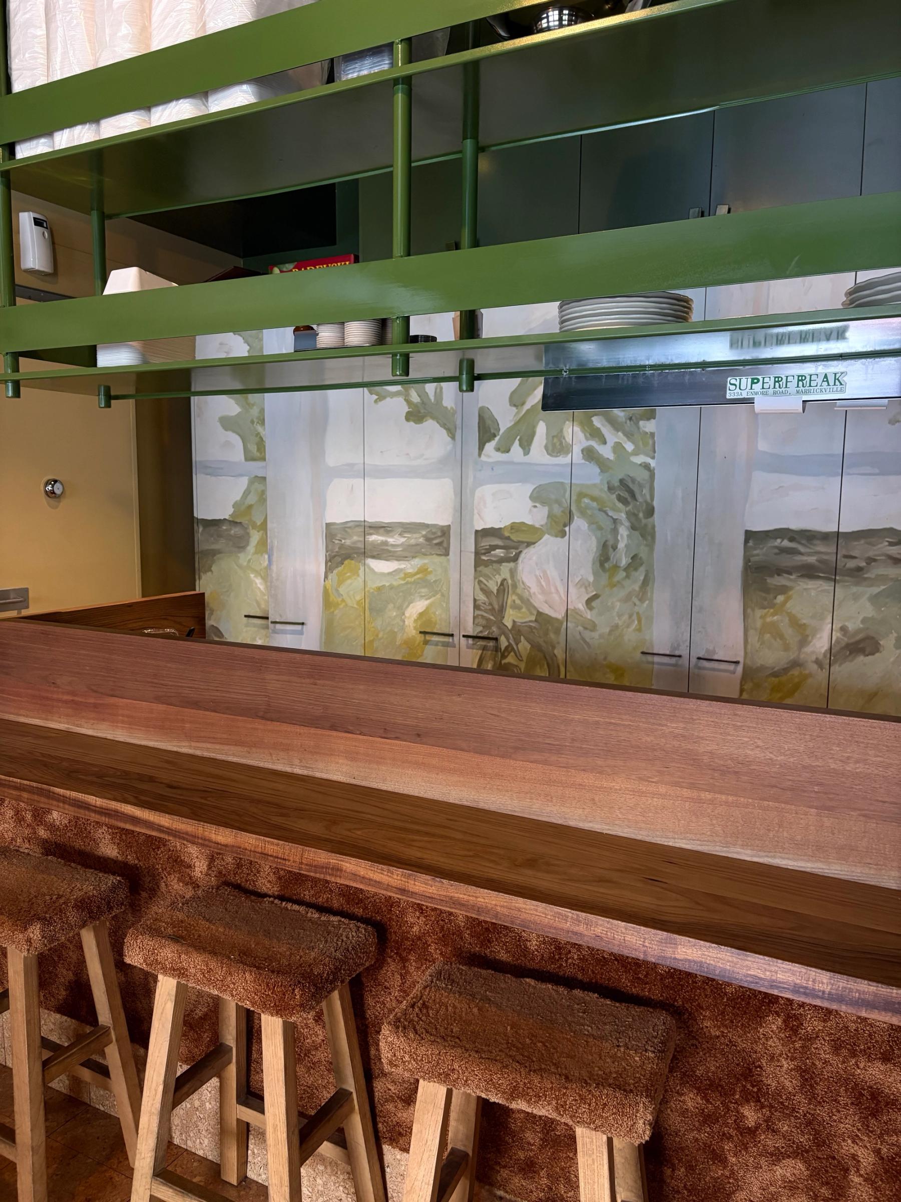 fuzzy material covered stools and a hand painted cabinet in a cafe kitchen