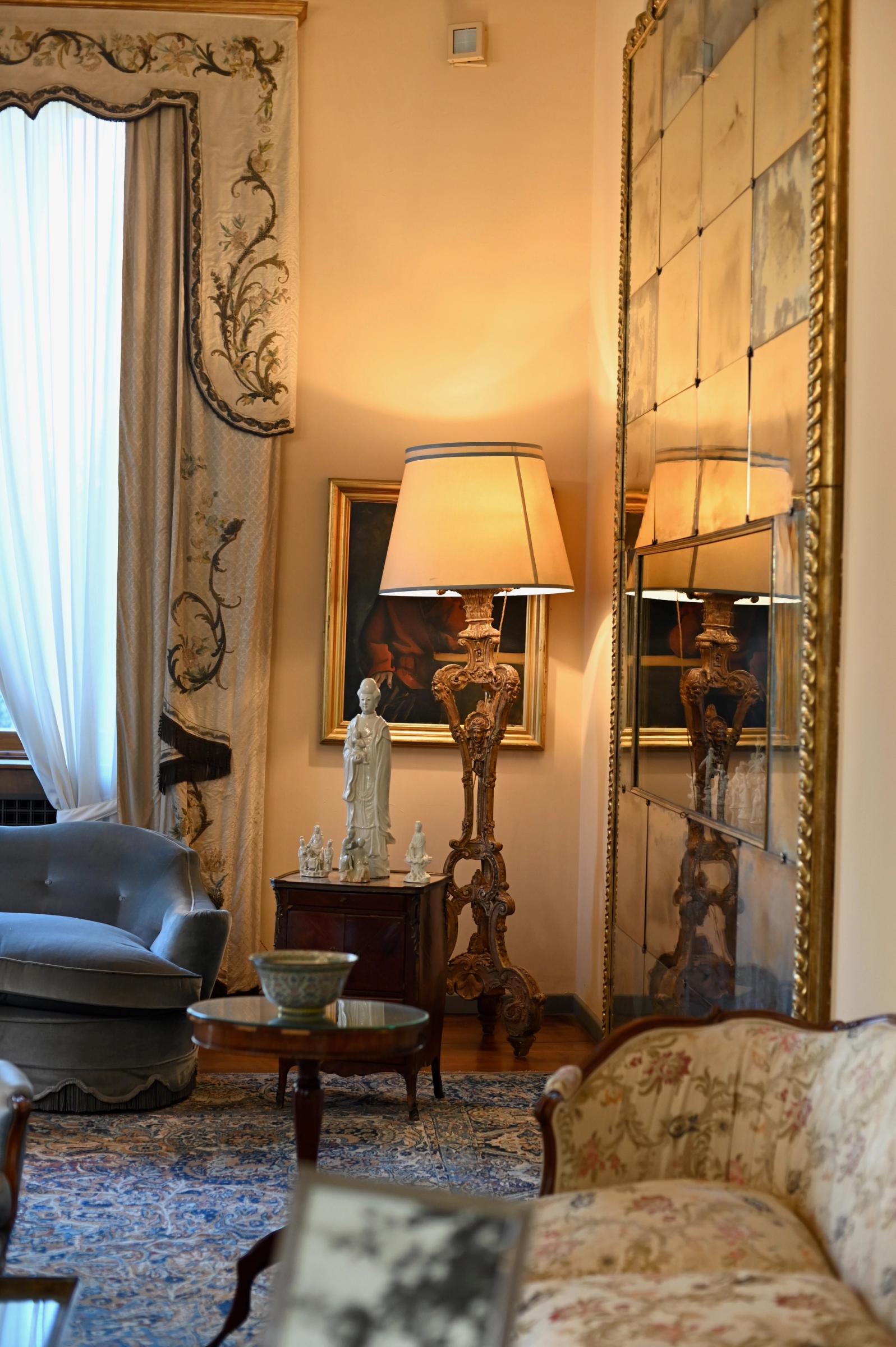 the lounge room featuring a statue, antique mirror and golden lamp