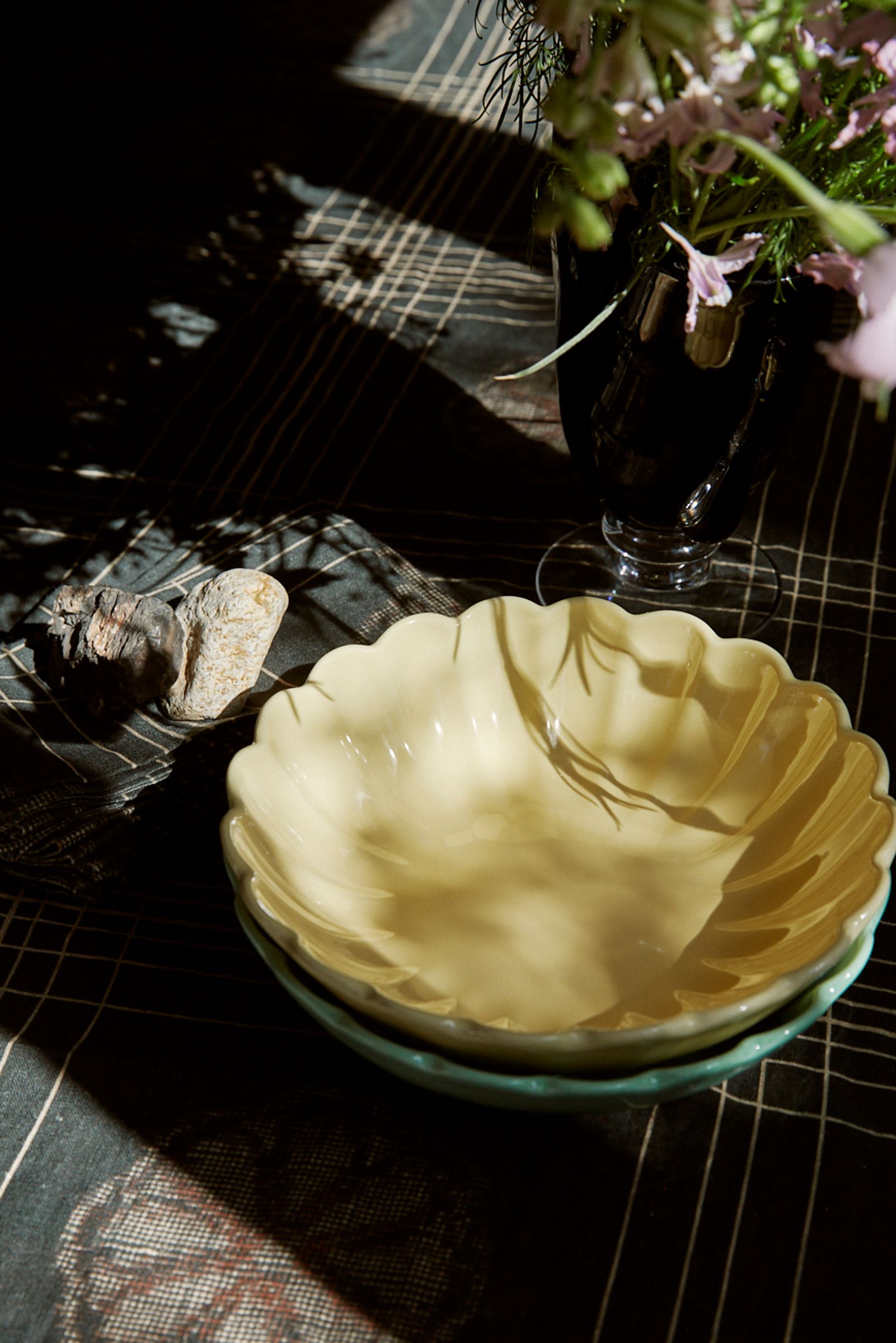 yellow bowl in the sun sitting on a dark charcoal tablecloth