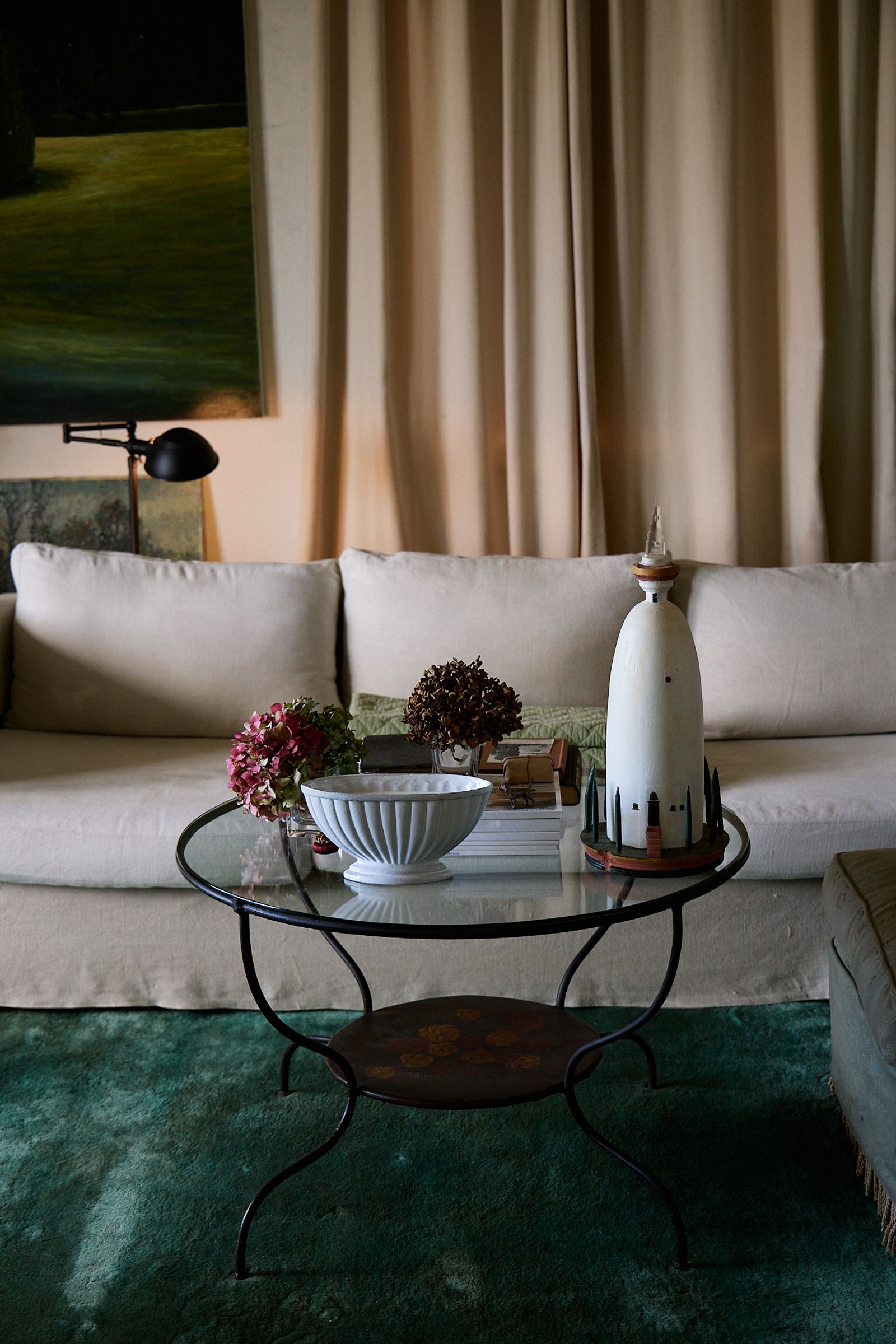 a lounge room with metal coffee table and green rug 