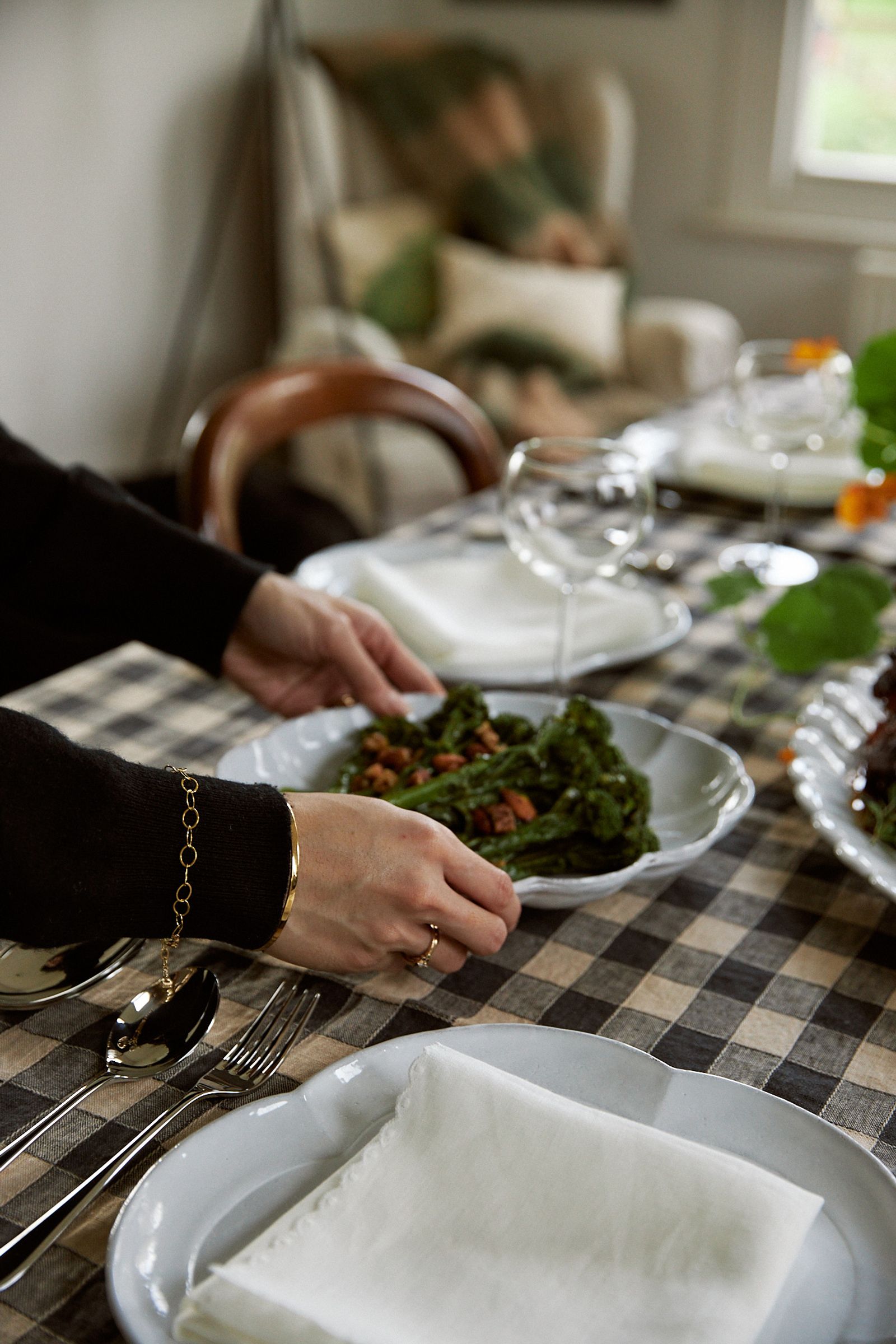 hand serving a side dish onto table with nasturtium