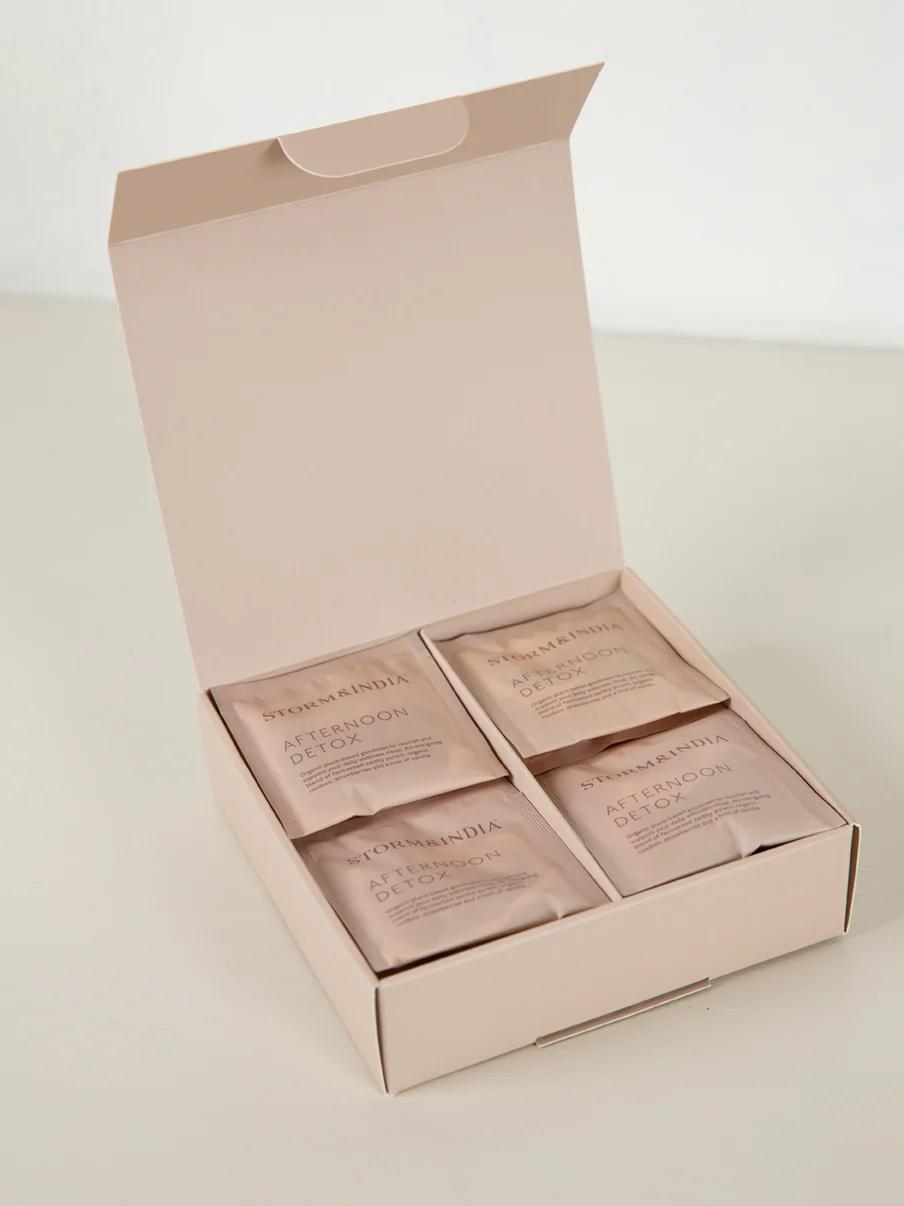 Light pink box with four "Afternoon Detox" tea packets from "Pukka x Nanda". Minimalist design showcases elegant packaging of organic Tasmanian tea.