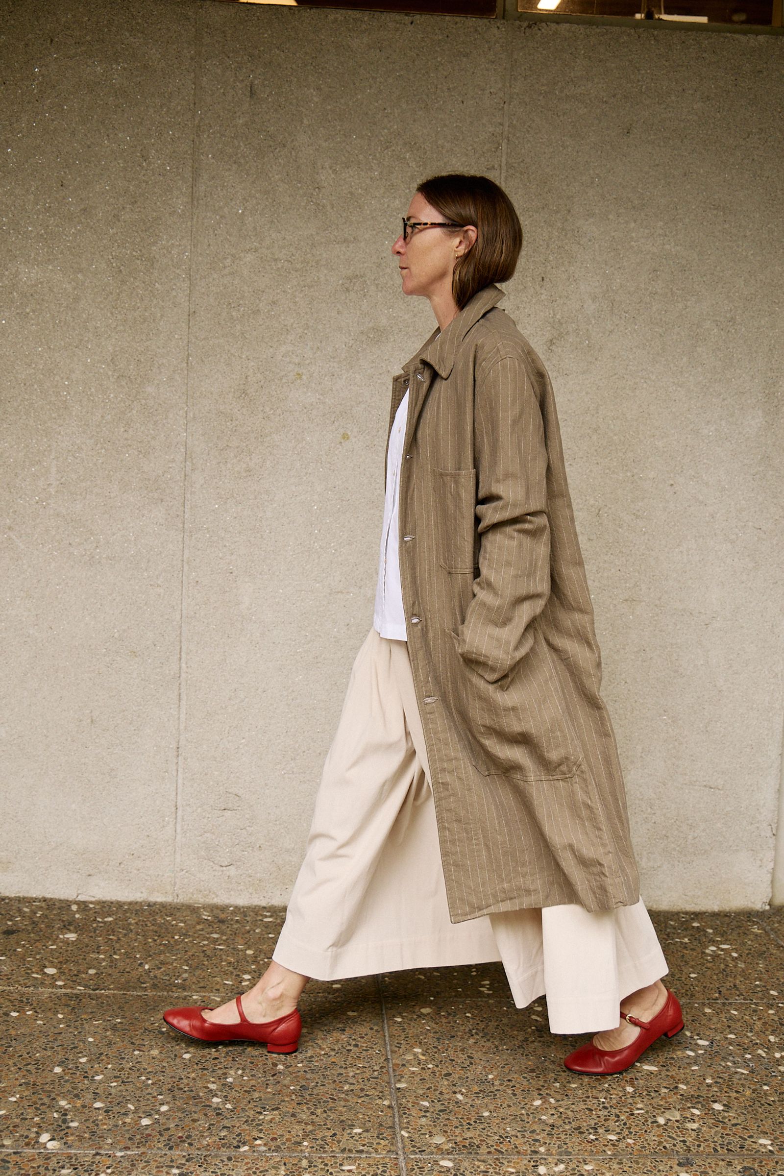 woman walking in soft wool coat and red shoes