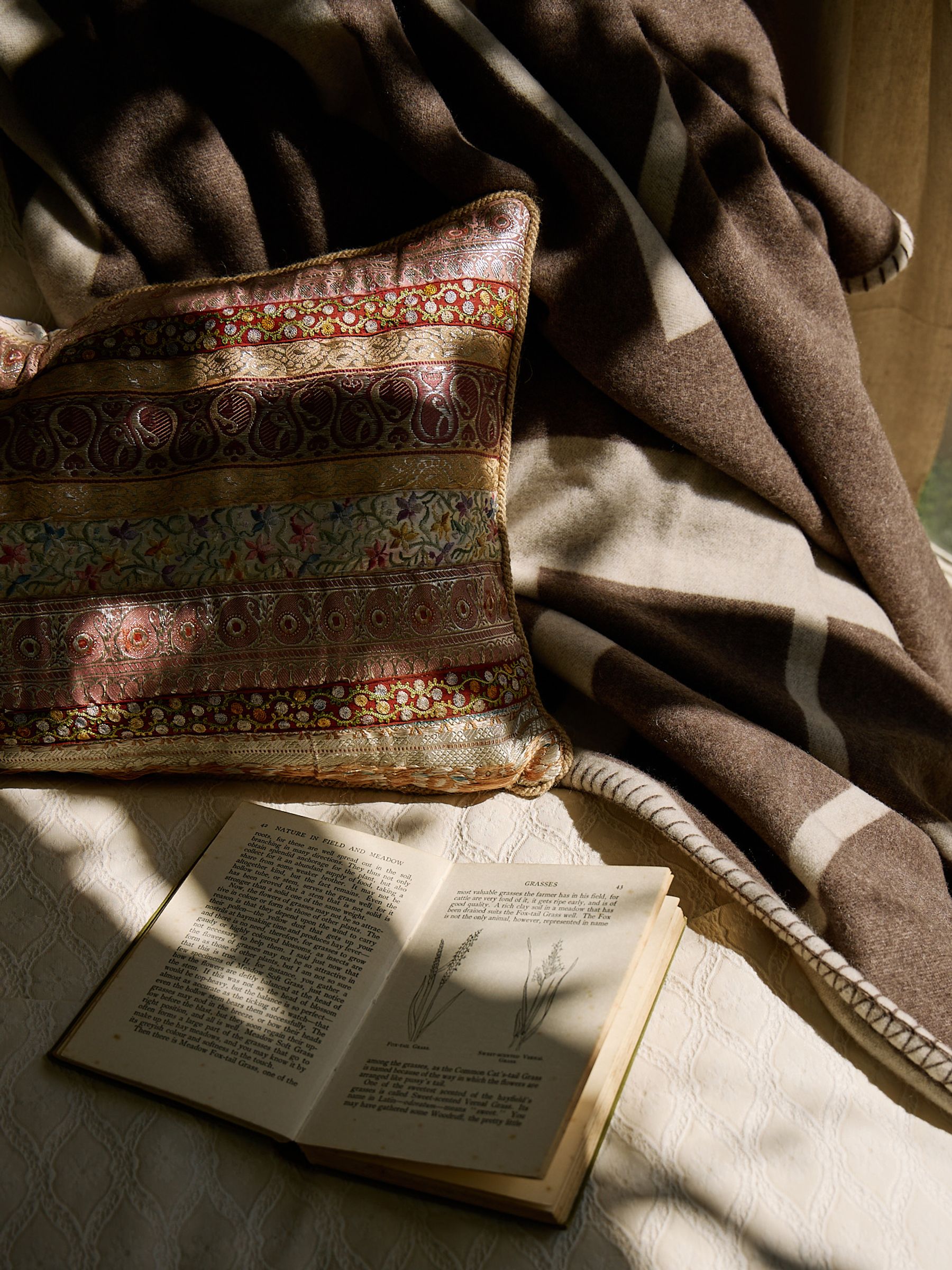 soft wool throw over a couch with pillow and book