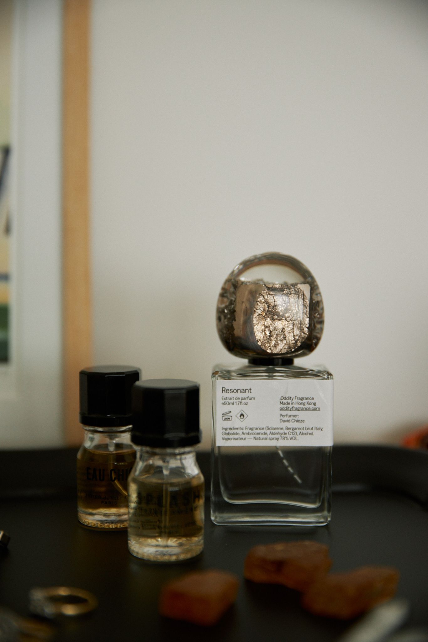 a perfume bottle with a round stone lid sits on top of a dresser 