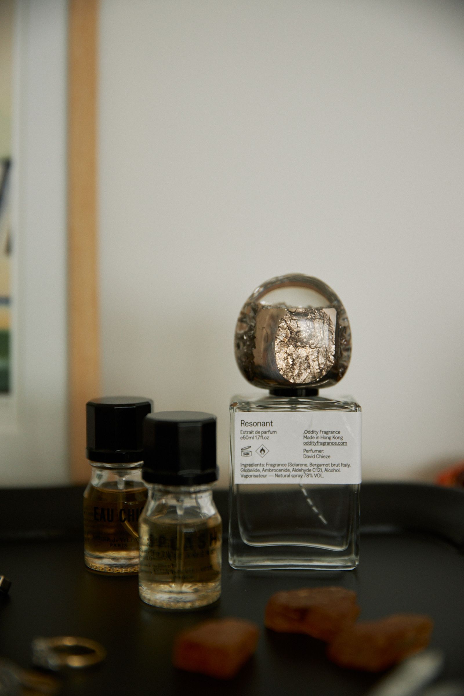 a perfume bottle with a round stone lid sits on top of a dresser
